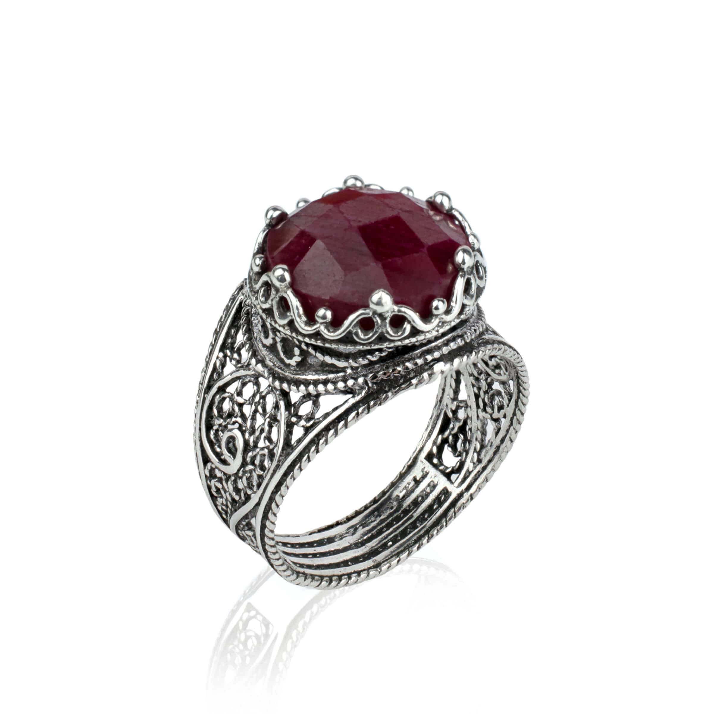 Handmade silver cocktail ring featuring an opaque ruby gemstone in a filigree crown design, showcasing intricate metalwork.