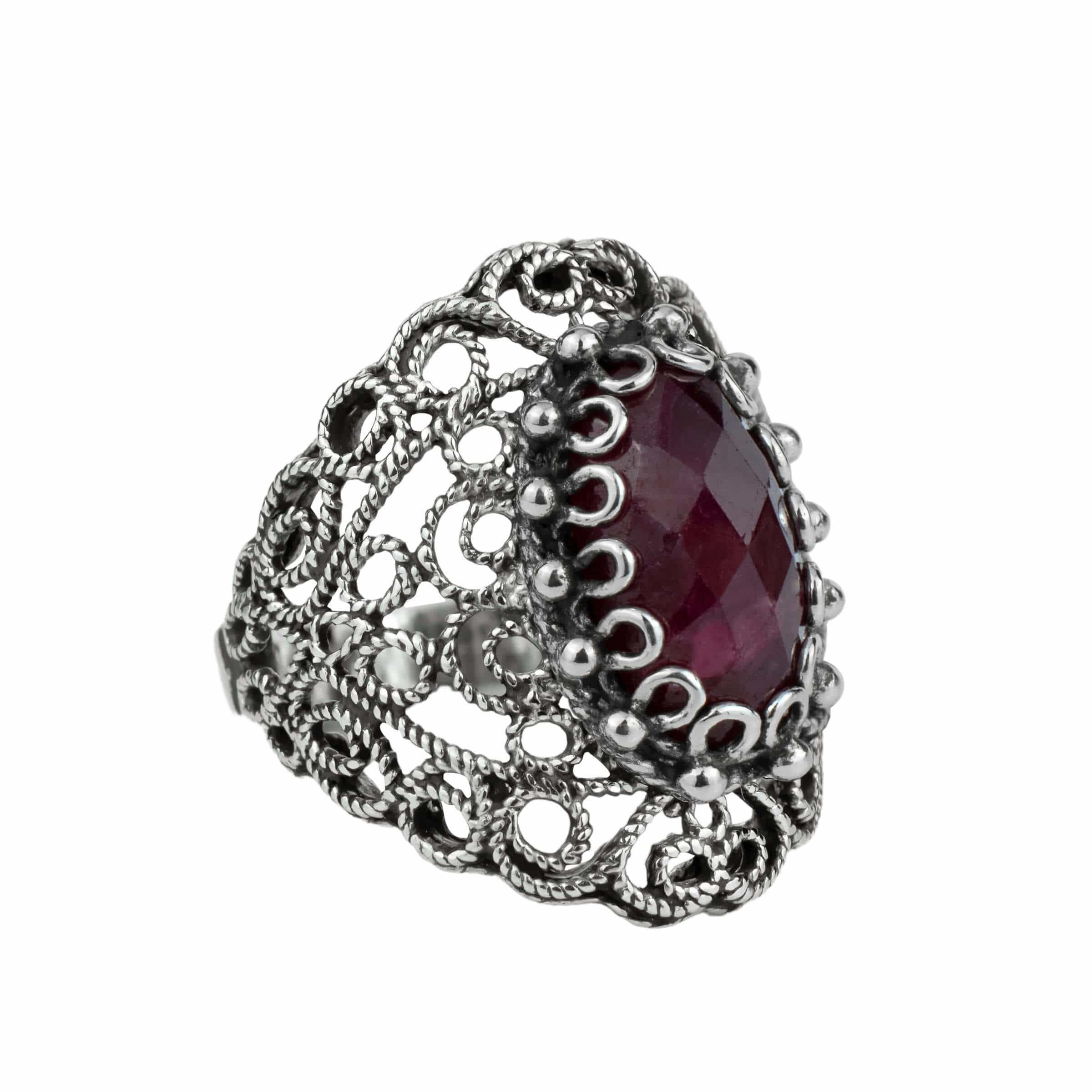 Handmade silver statement ring featuring filigree art and an opaque ruby corundum gemstone, showcasing intricate lace detailing.