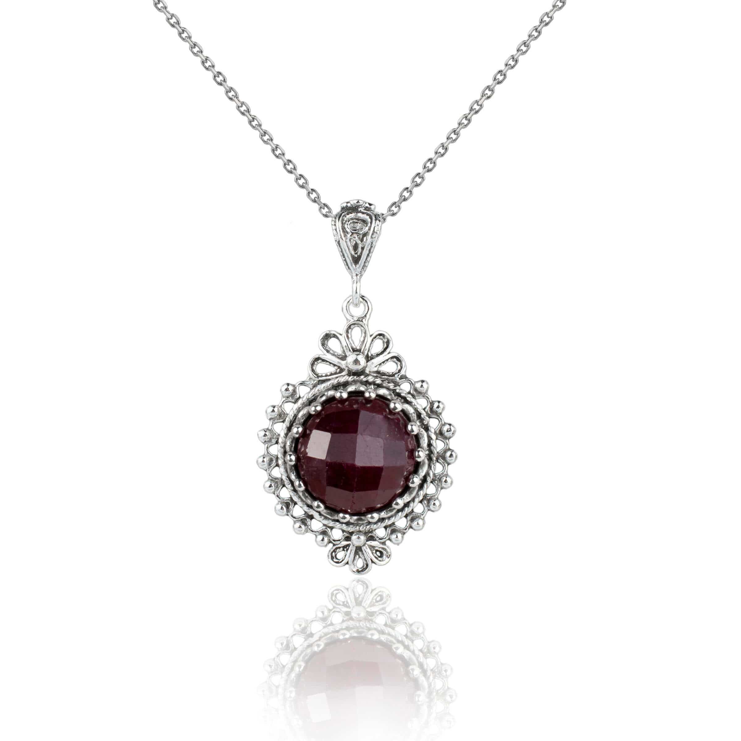 Elegant silver boho pendant necklace featuring a ruby corundum gemstone in filigree design, showcasing intricate craftsmanship.