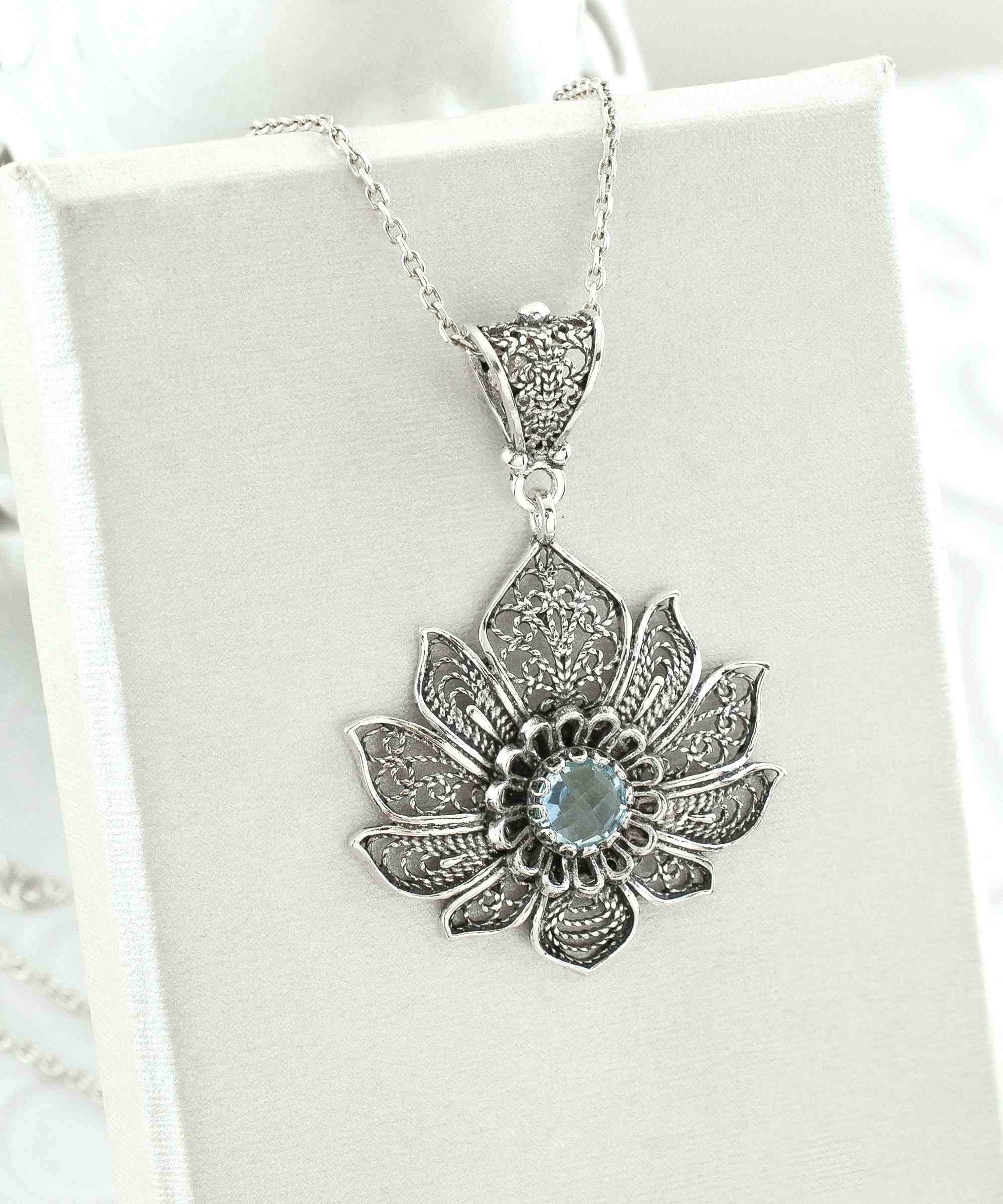 Handcrafted 925 Sterling Silver Lotus Flower Pendant with Blue Topaz gemstone, showcasing intricate filigree design.
