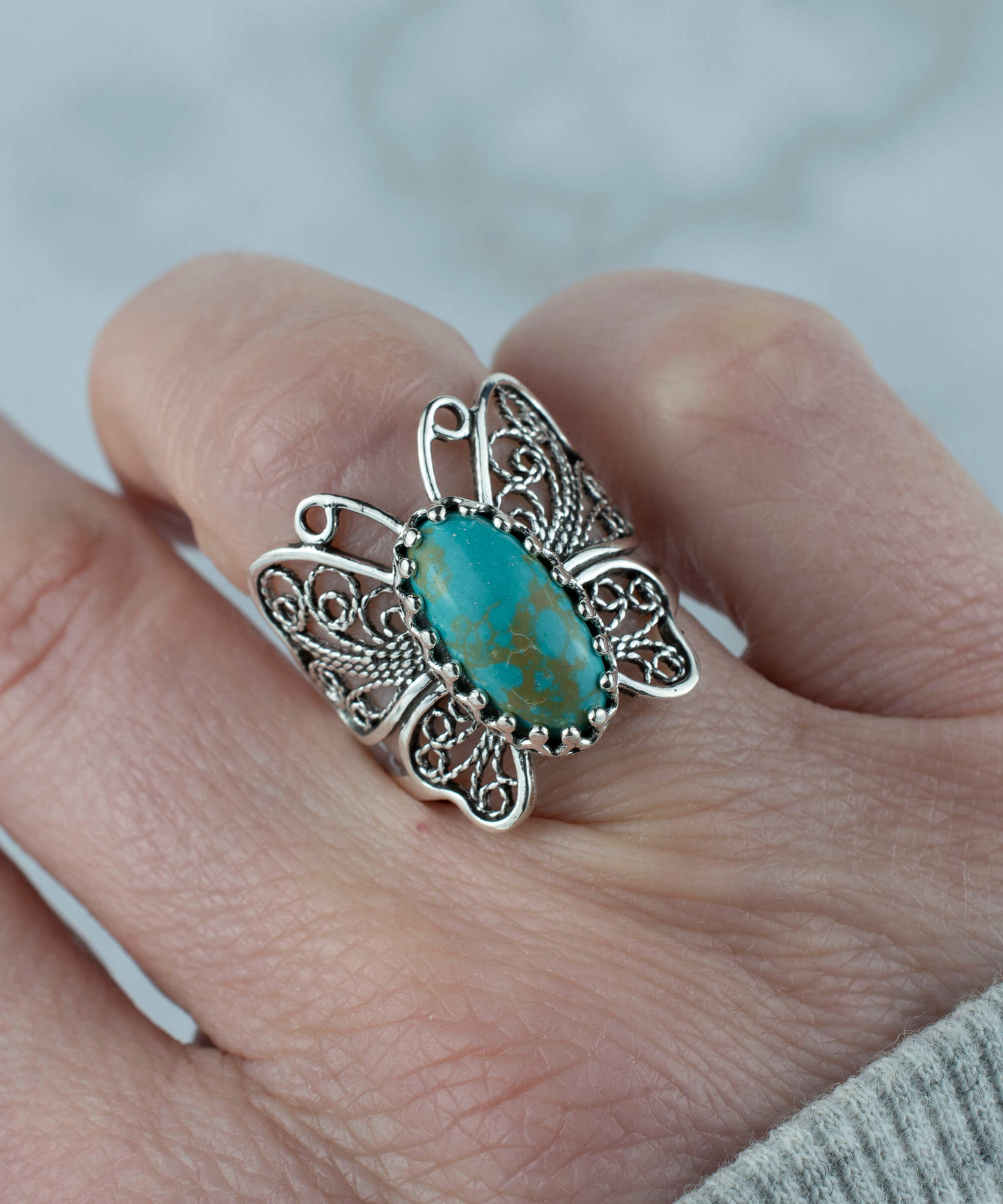 Sterling silver filigree butterfly cocktail ring featuring a turquoise gemstone, elegantly designed for women.