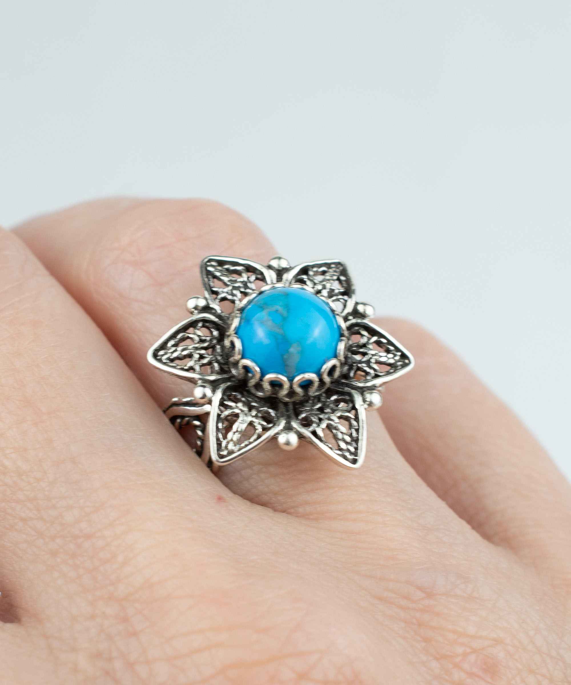 Elegant 925 sterling silver cocktail ring featuring a turquoise gemstone and intricate daisy flower filigree design.