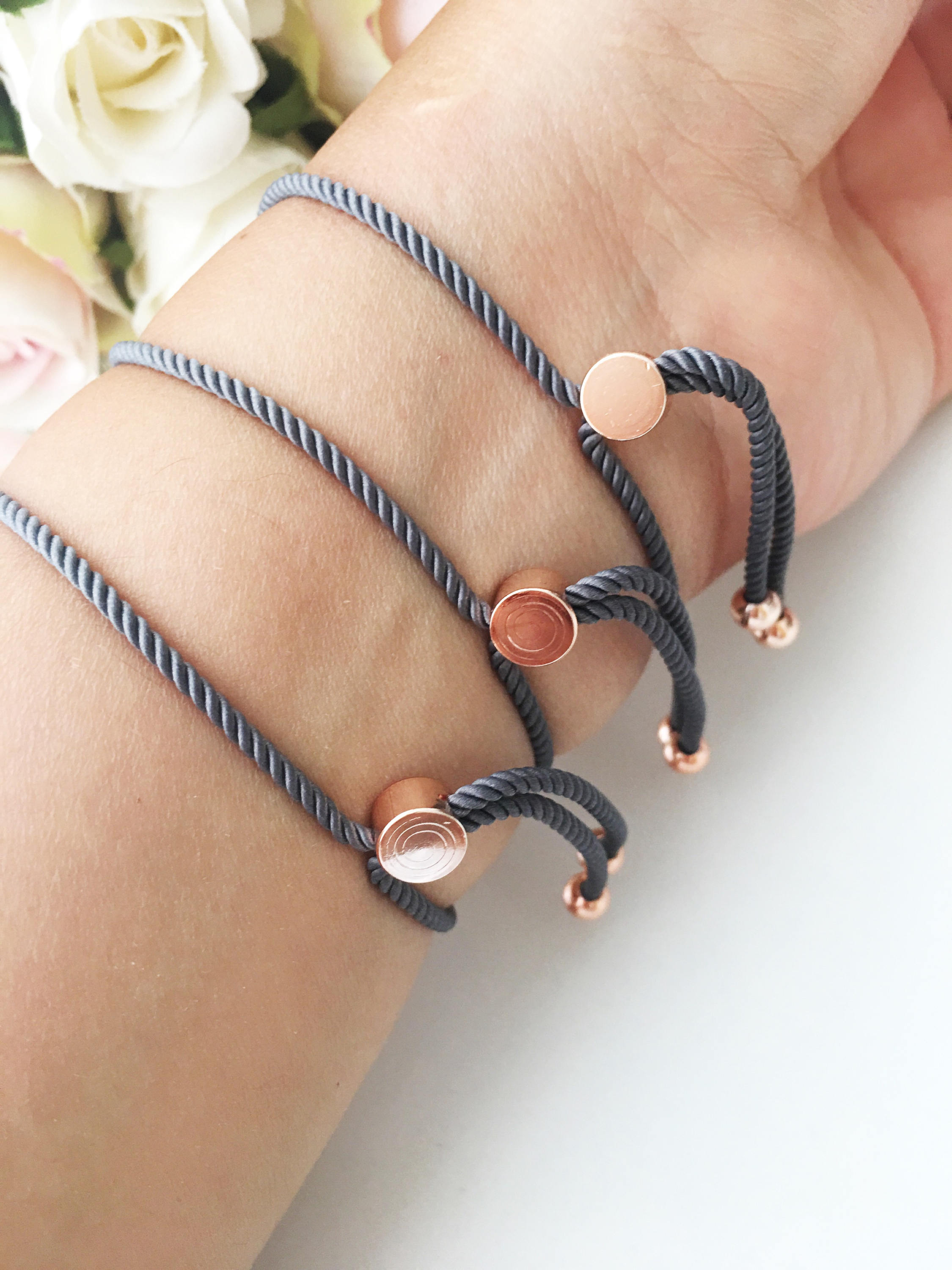 A stylish Fish Charm Bracelet featuring a rose gold plated evil eye charm on an adjustable string, perfect for everyday wear.