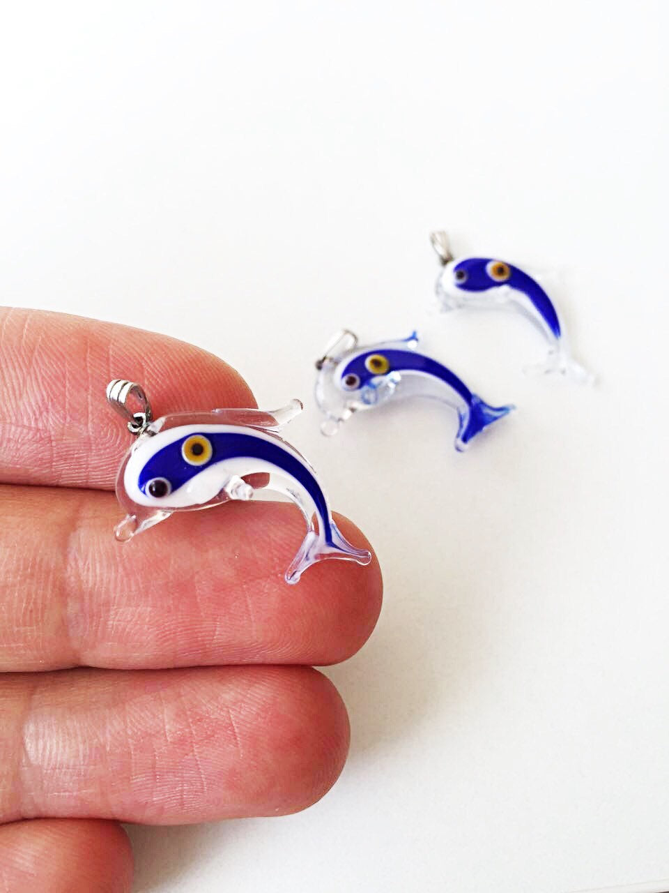 Blue dolphin-shaped glass pendants.