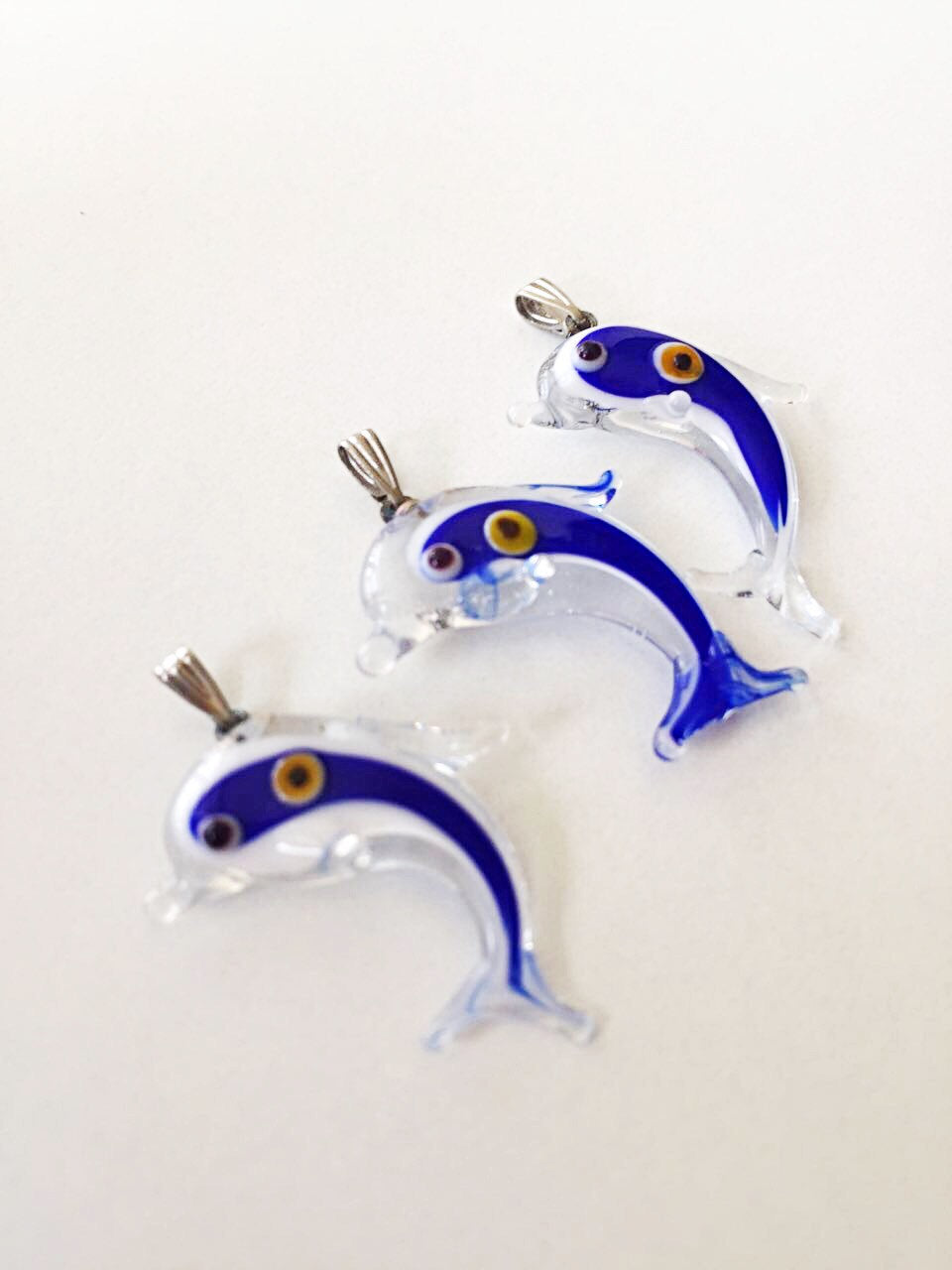 Glass dolphin-shaped pendants.