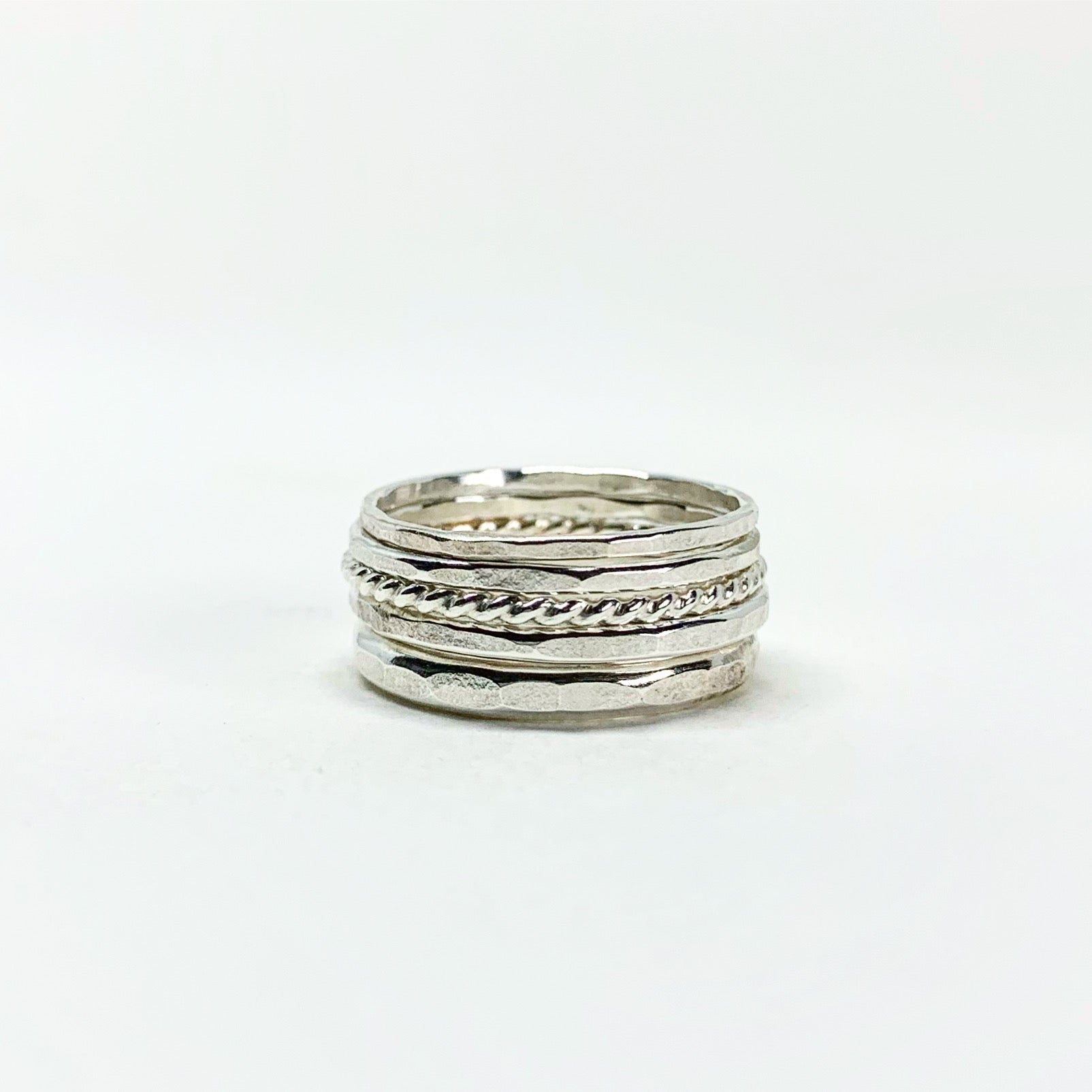 Bridal Stacking Ring Set featuring five textured rings with hammered and twisted designs, handmade from recycled metals.