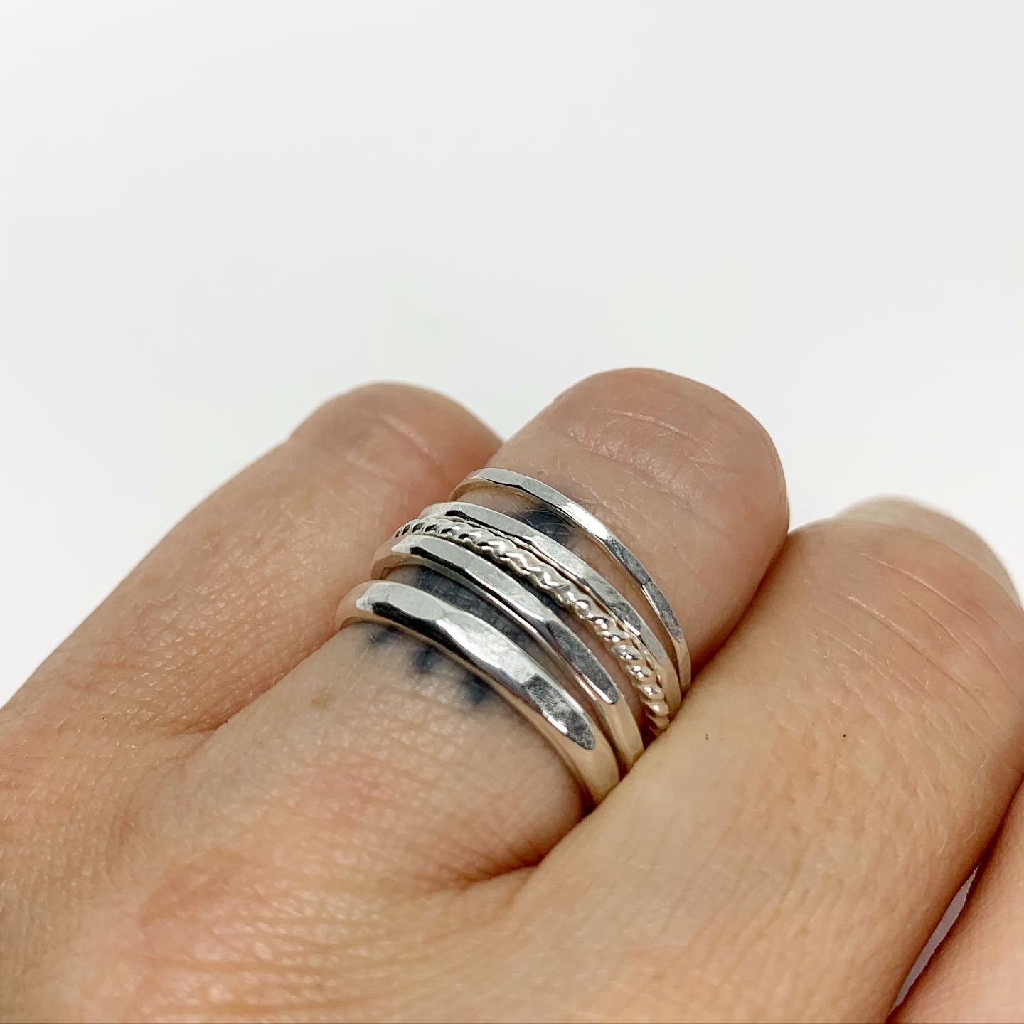 Bridal Stacking Ring Set featuring five textured rings with hammered and twisted designs, handmade from recycled metals.