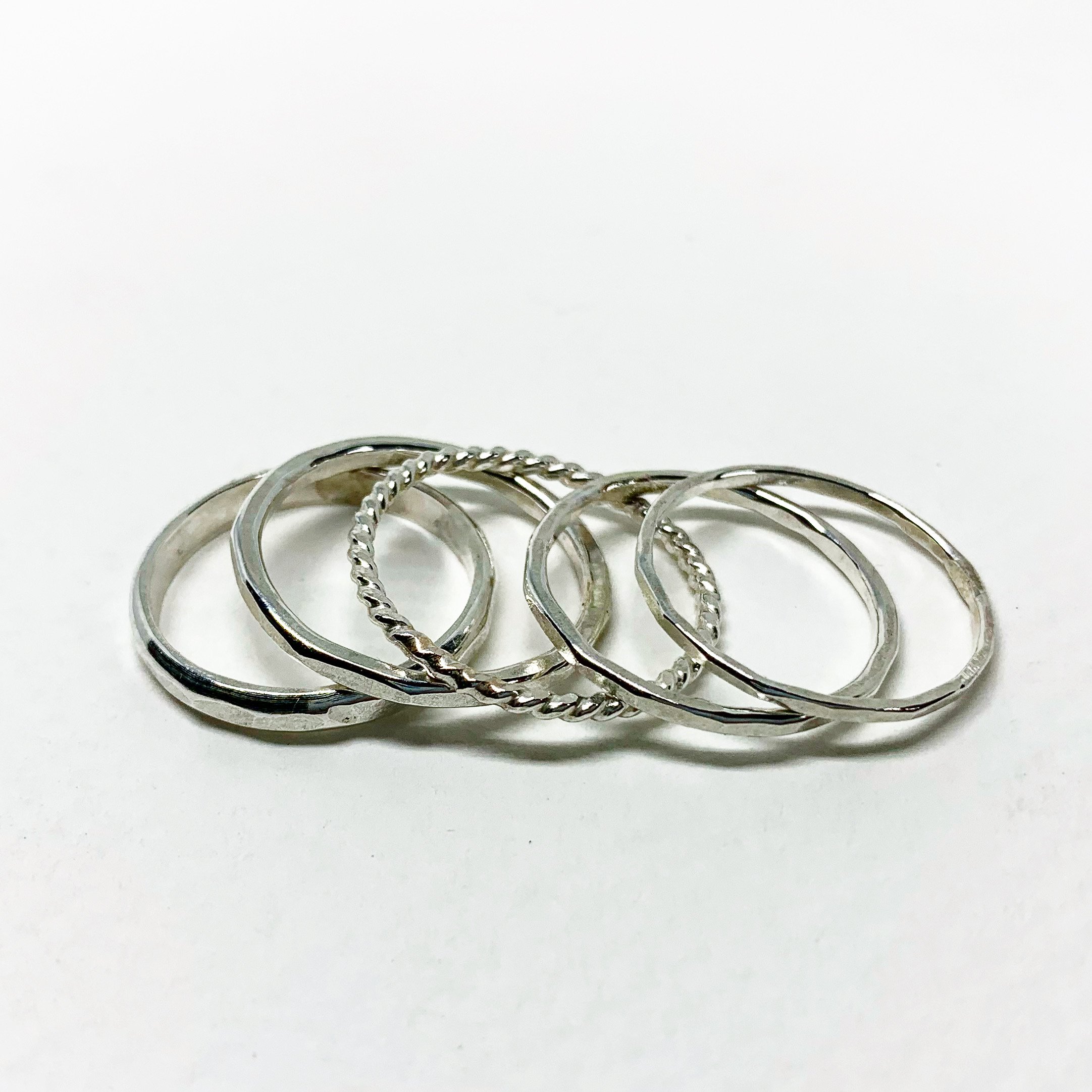 Bridal Stacking Ring Set featuring five textured rings with hammered and twisted designs, handmade from recycled metals.