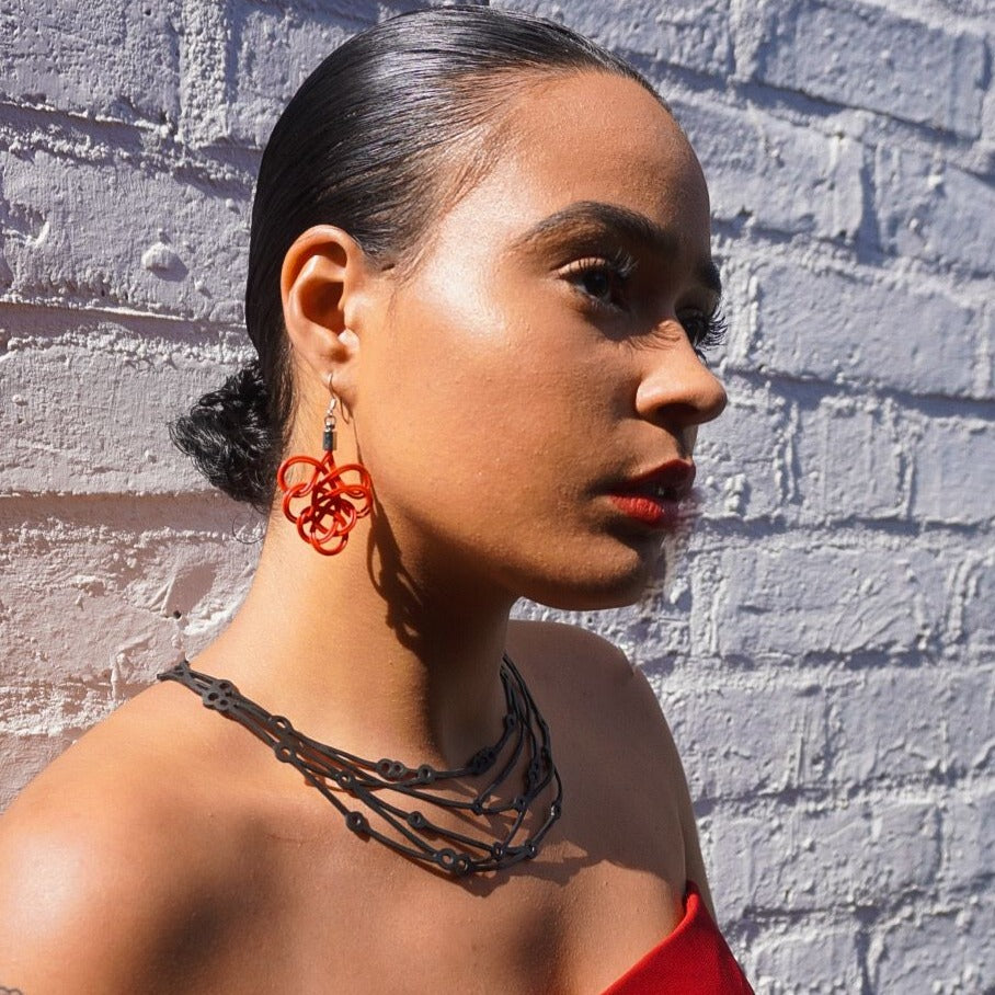 Flare Reclaimed Rubber Necklace made from recycled tyre inner tubes, featuring a multi-strap design and a button snap fastener.