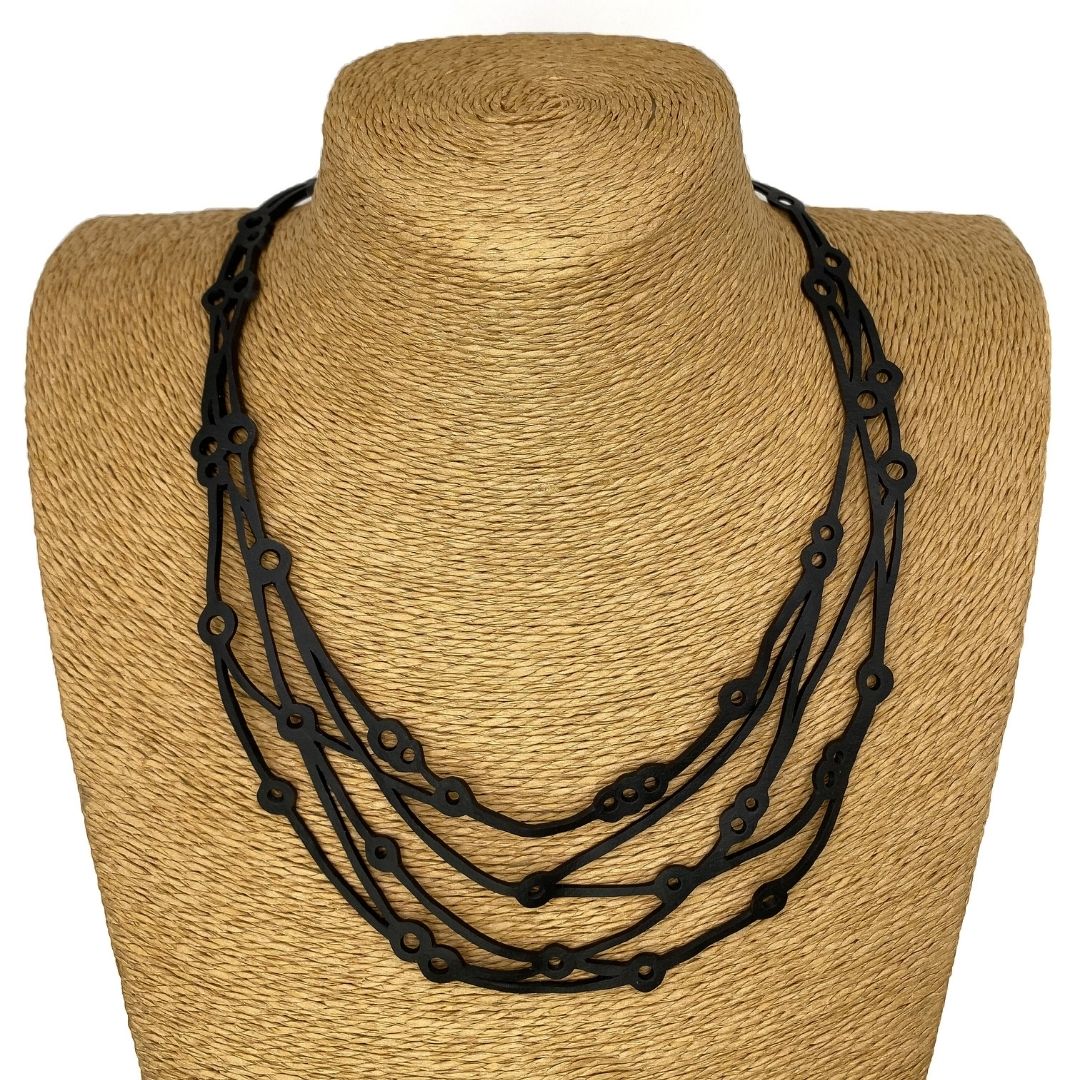 Flare Reclaimed Rubber Necklace made from recycled tyre inner tubes, featuring a multi-strap design and a button snap fastener.