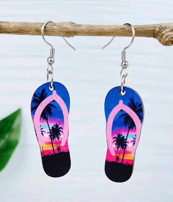 Wooden flip flop earrings with palm tree design, hanging from metal fishhooks.