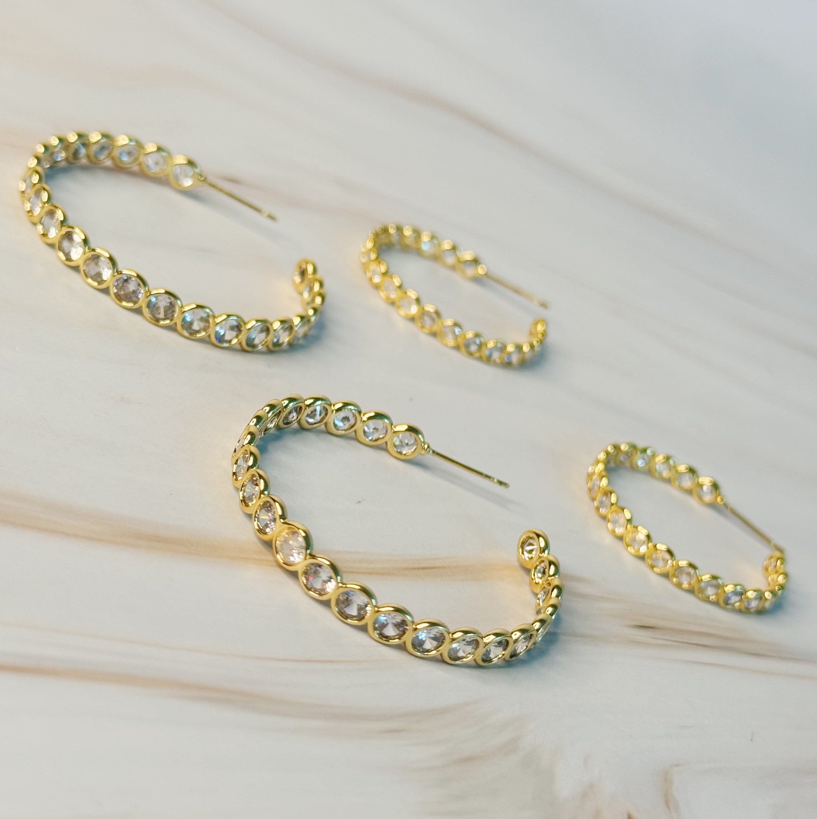 Elegant Floating Bezel Crystal Hoop Earrings with sparkling cubic zirconia set in 18K gold plated brass, showcasing a stylish design.