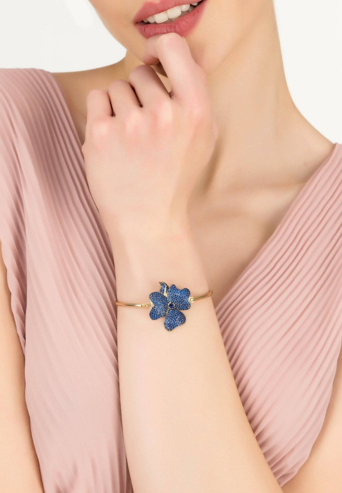 Elegant Flower Large Statement Cuff Bracelet in gold with sapphire blue zirconia, featuring a floral design on a polished metallic bangle.