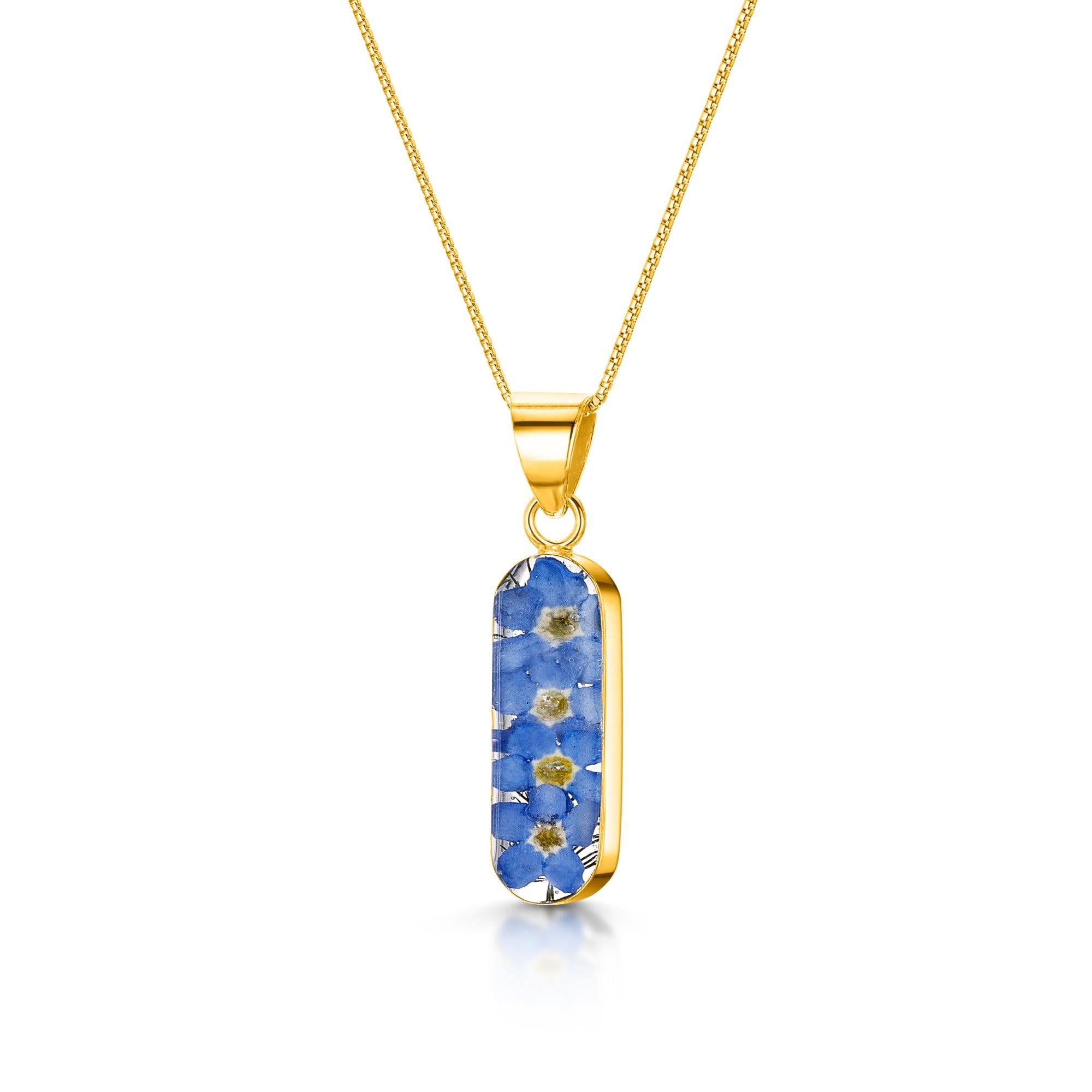 Forget Me Not necklace 'Leela' featuring a vertical bar pendant with real blue flowers encased in resin, on a sterling silver chain.