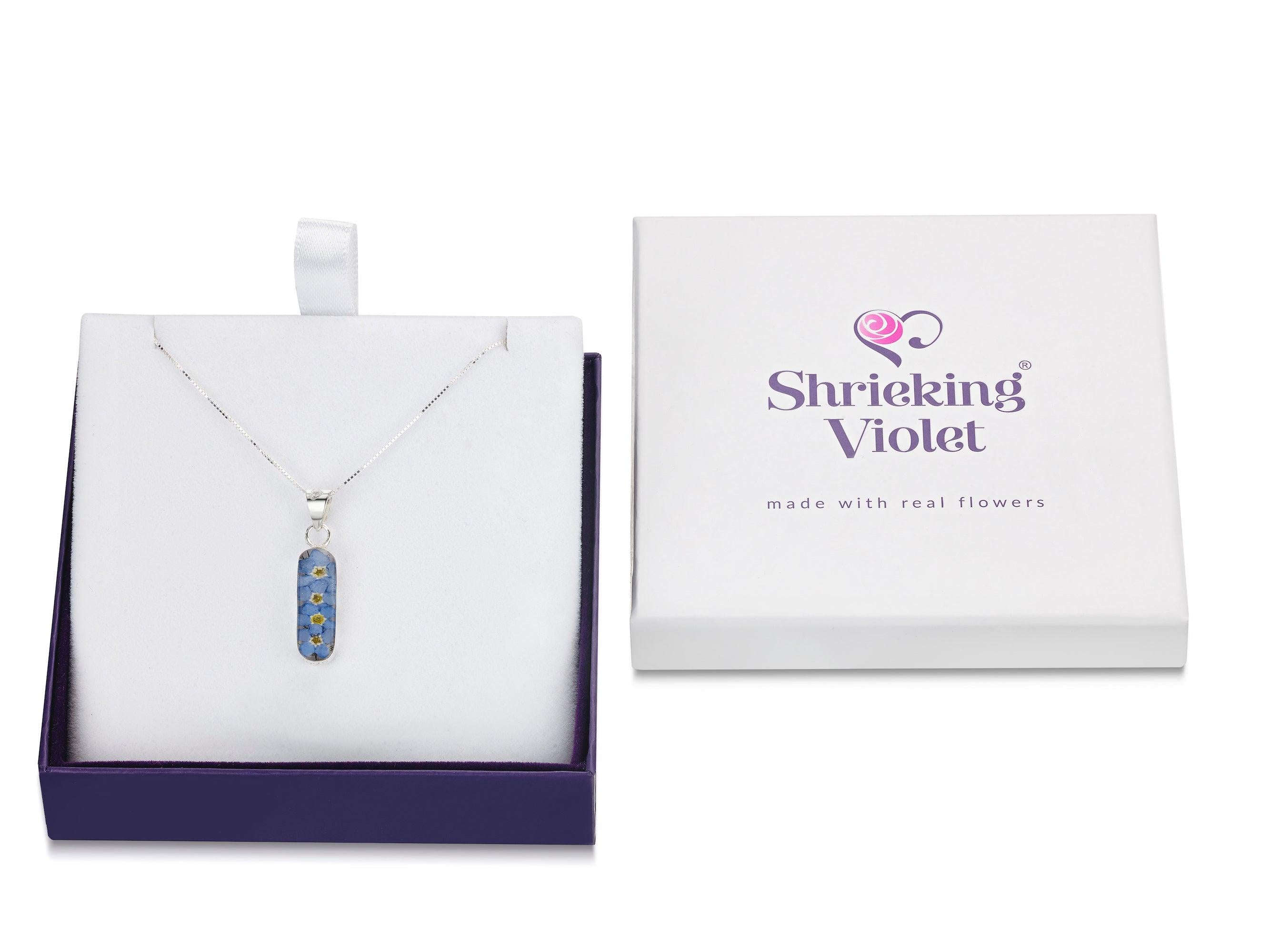 Forget Me Not necklace 'Leela' featuring a vertical bar pendant with real blue flowers encased in resin, on a sterling silver chain.