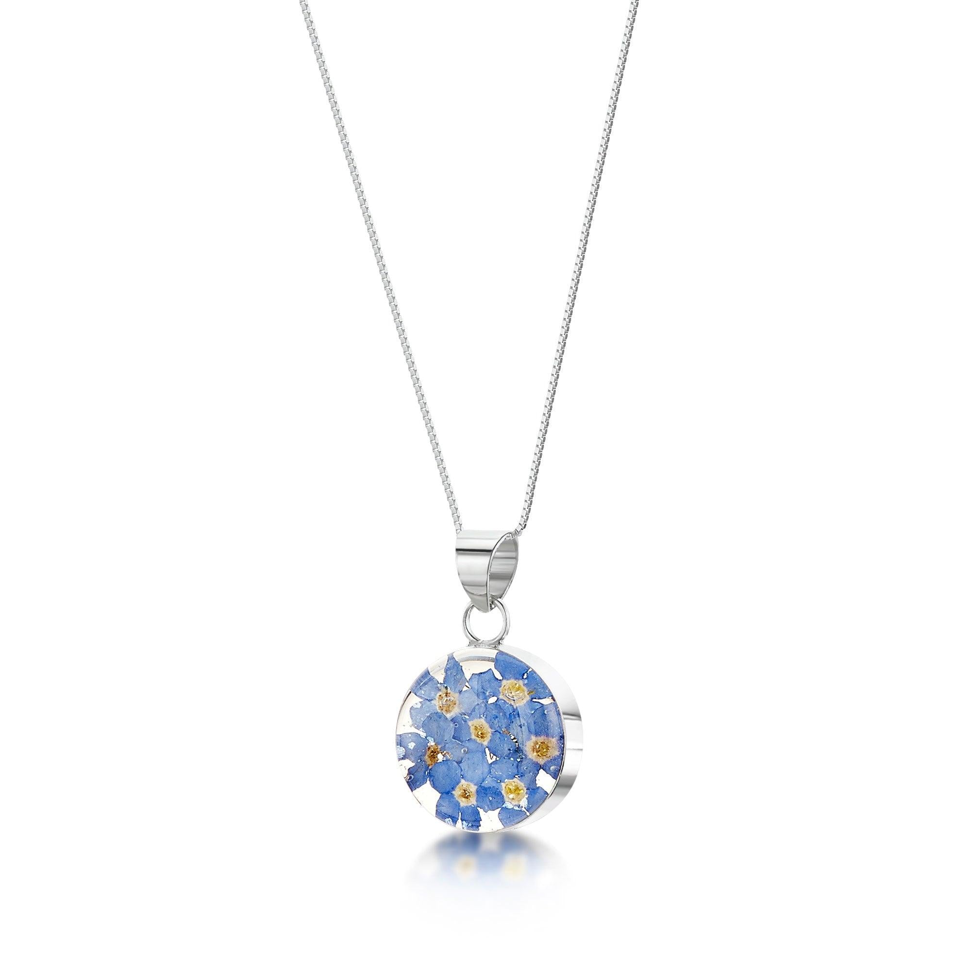 Forget-me-not necklace featuring real flowers in a sterling silver round pendant with an adjustable chain, elegantly presented in a gift box.