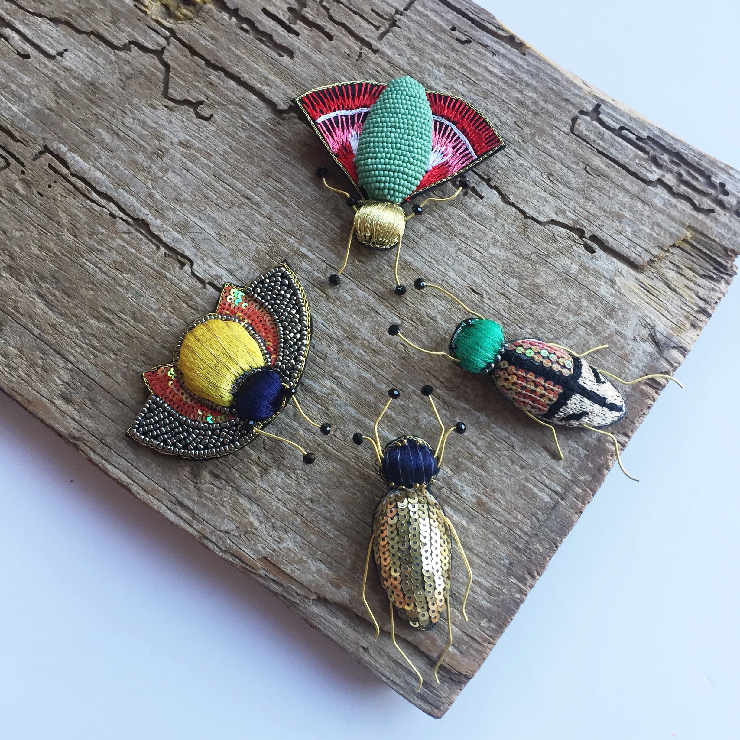 A handcrafted Francis Bug Brooch featuring vibrant colors and intricate details, showcasing a whimsical insect design made from seed beads and silk.