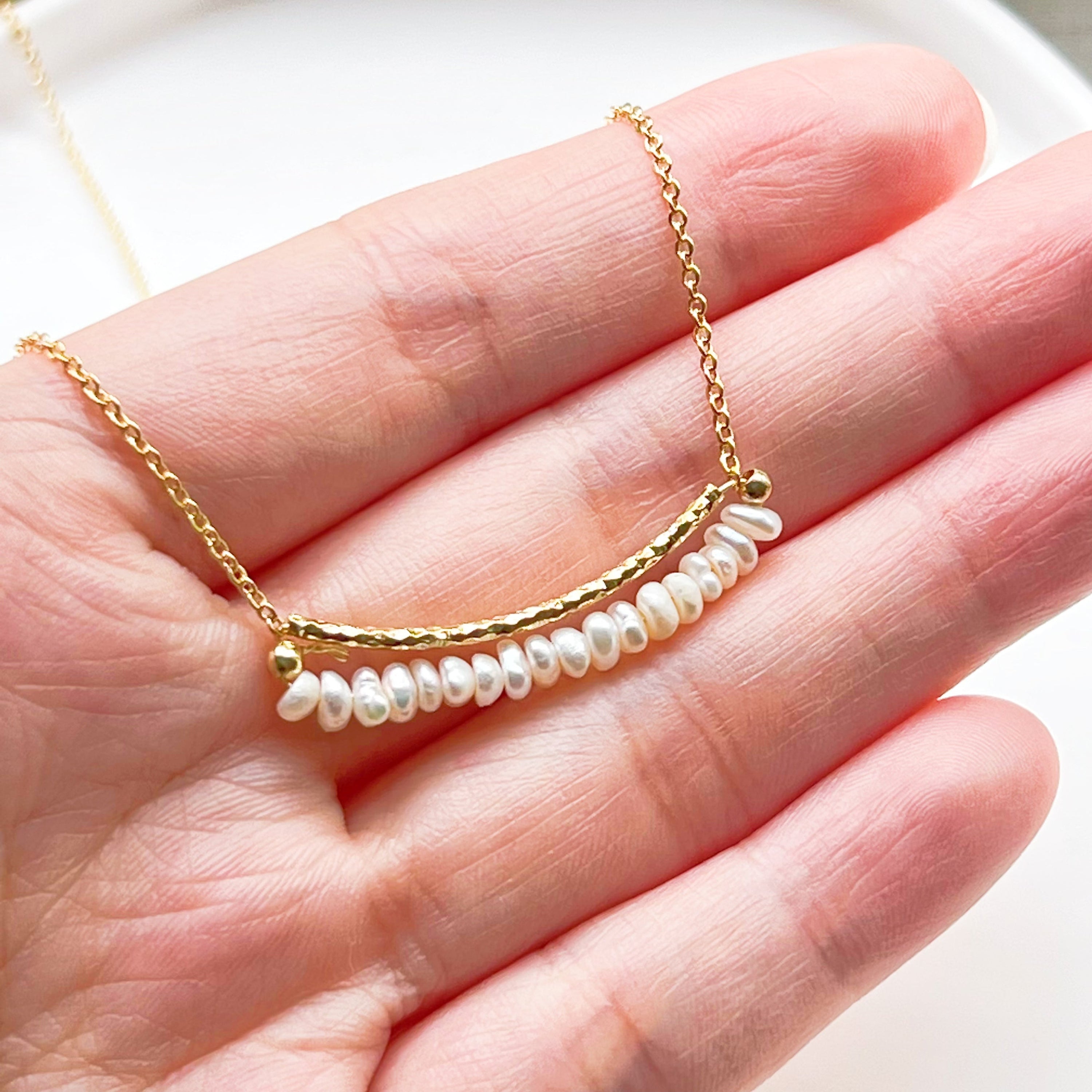 A delicate Freshwater Pearl Gold Bar Necklace featuring baroque pearls on a gold-plated chain, elegantly displayed in a gift box.