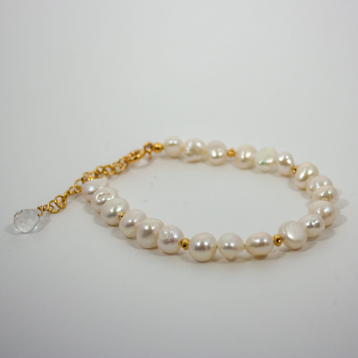 A stylish Freshwater Pearl Gold Chain Bracelet featuring baroque pearls and a quartz briolette accent, elegantly displayed on a soft surface.