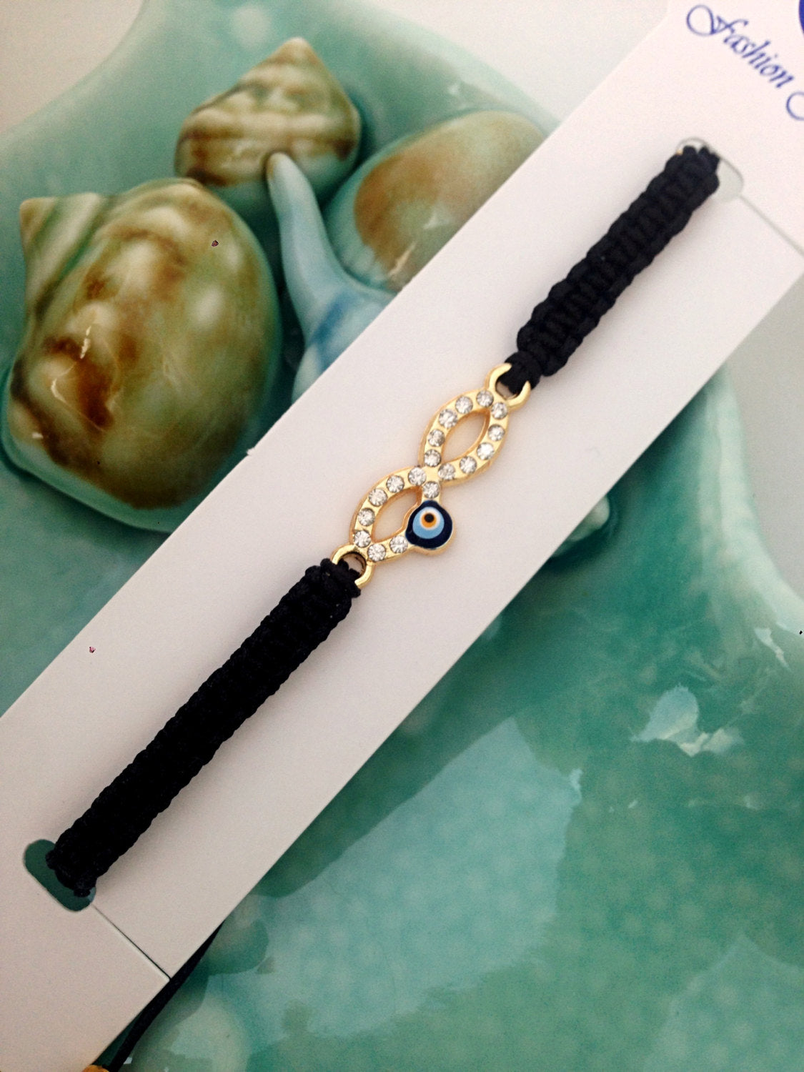 Handmade Infinity Evil Eye Bracelet featuring a silver-plated hamsa hand and evil eye charm on black macramé.