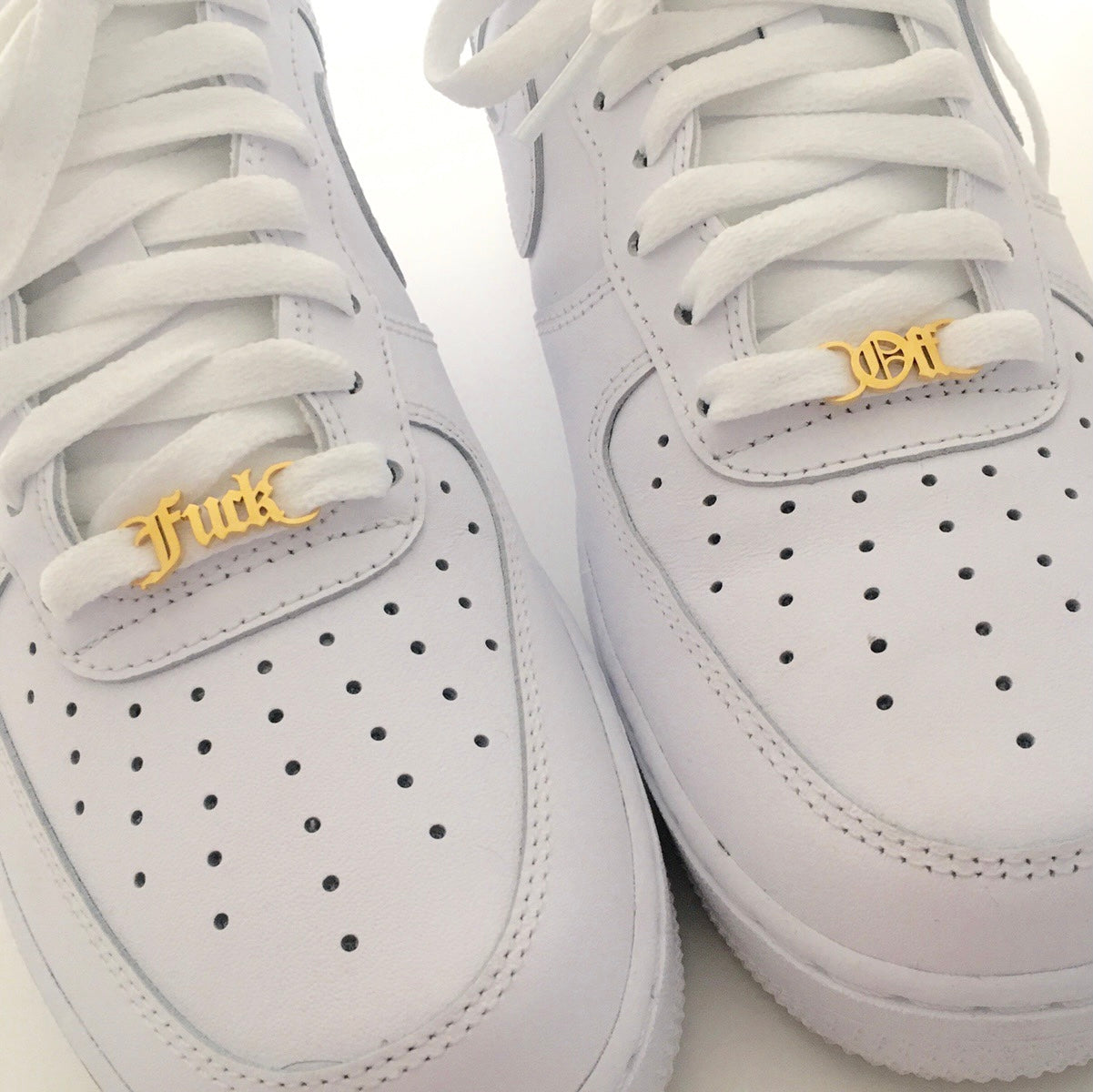 A pair of stainless steel Fuck Off Shoelace Buckles in various colors, showcasing their sleek design and durability.