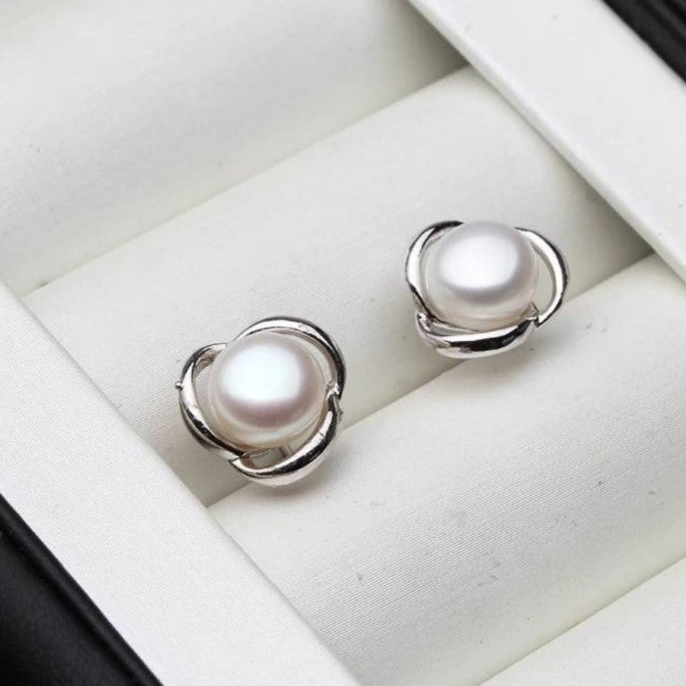 A pair of Genuine Freshwater Pearl Classic Swirl Stud Earrings in various colors, showcasing their elegant design and lustrous pearls.