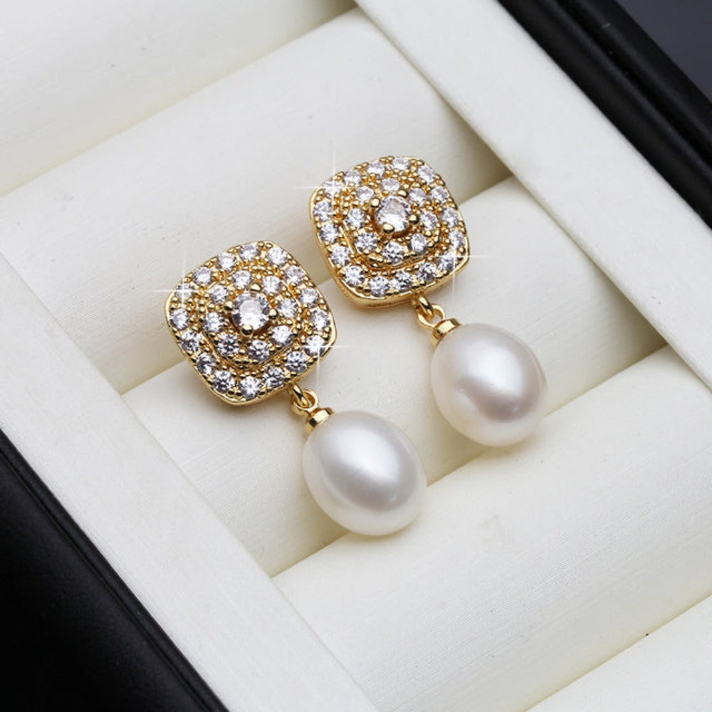 Elegant drop earrings featuring genuine freshwater pearls and simulated diamonds set in gold, available in various colors.