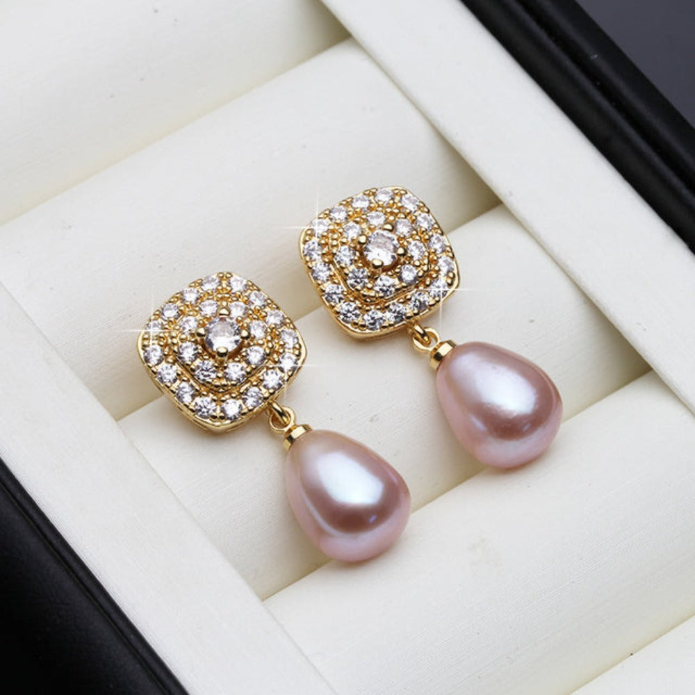 Elegant drop earrings featuring genuine freshwater pearls and simulated diamonds set in gold, available in various colors.