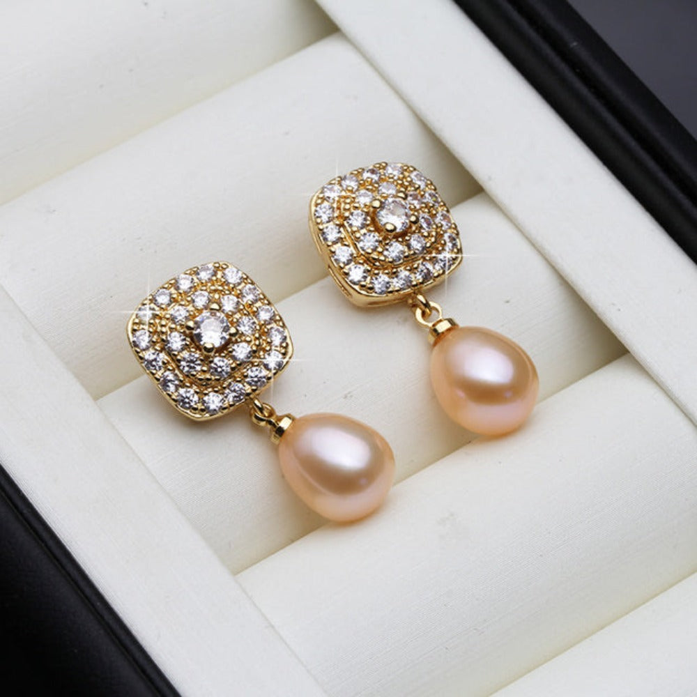 Elegant drop earrings featuring genuine freshwater pearls and simulated diamonds set in gold, available in various colors.