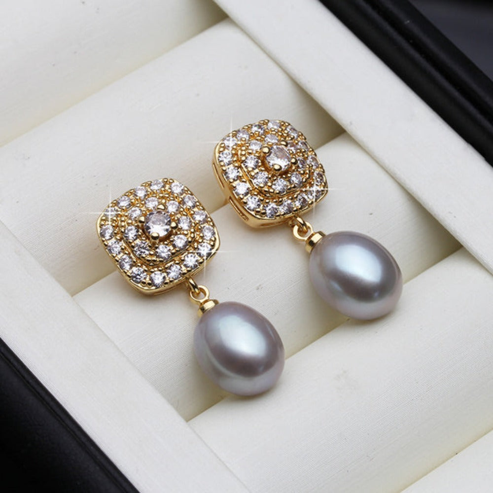 Elegant drop earrings featuring genuine freshwater pearls and simulated diamonds set in gold, available in various colors.