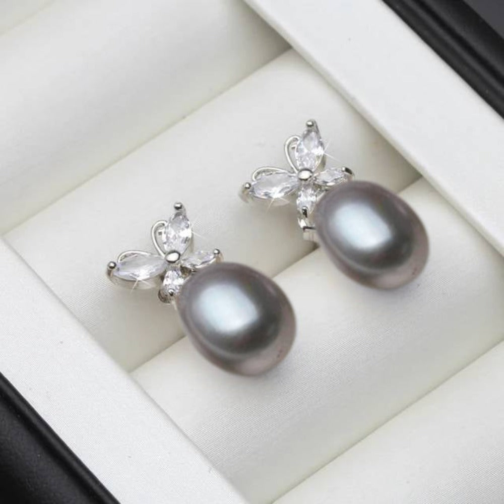 Elegant butterfly stud earrings featuring genuine white freshwater pearls and simulated diamonds, showcasing a delicate design.