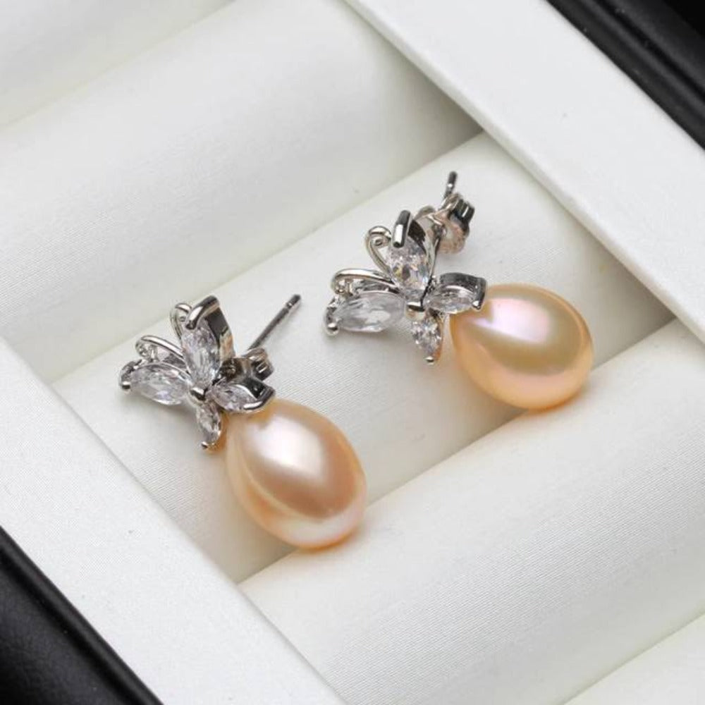 Elegant butterfly stud earrings featuring genuine white freshwater pearls and simulated diamonds, showcasing a delicate design.