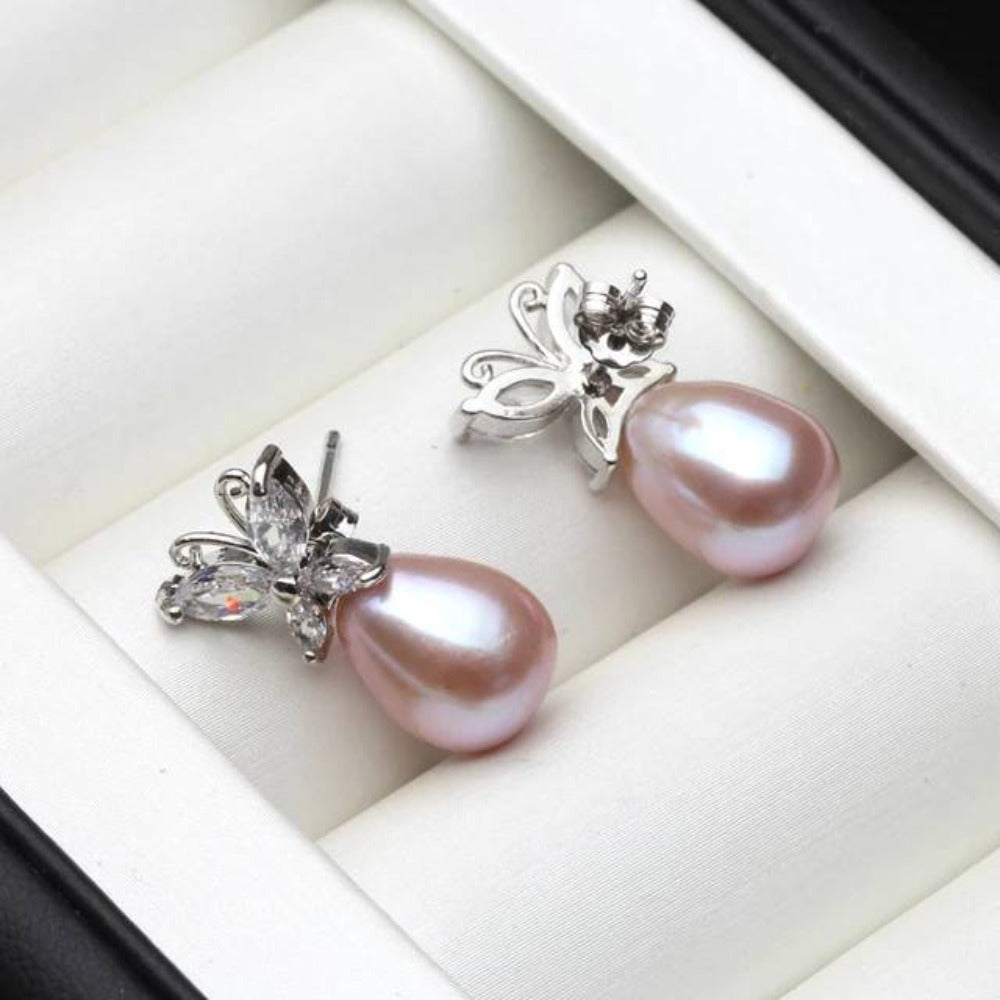 Elegant butterfly stud earrings featuring genuine white freshwater pearls and simulated diamonds, showcasing a delicate design.