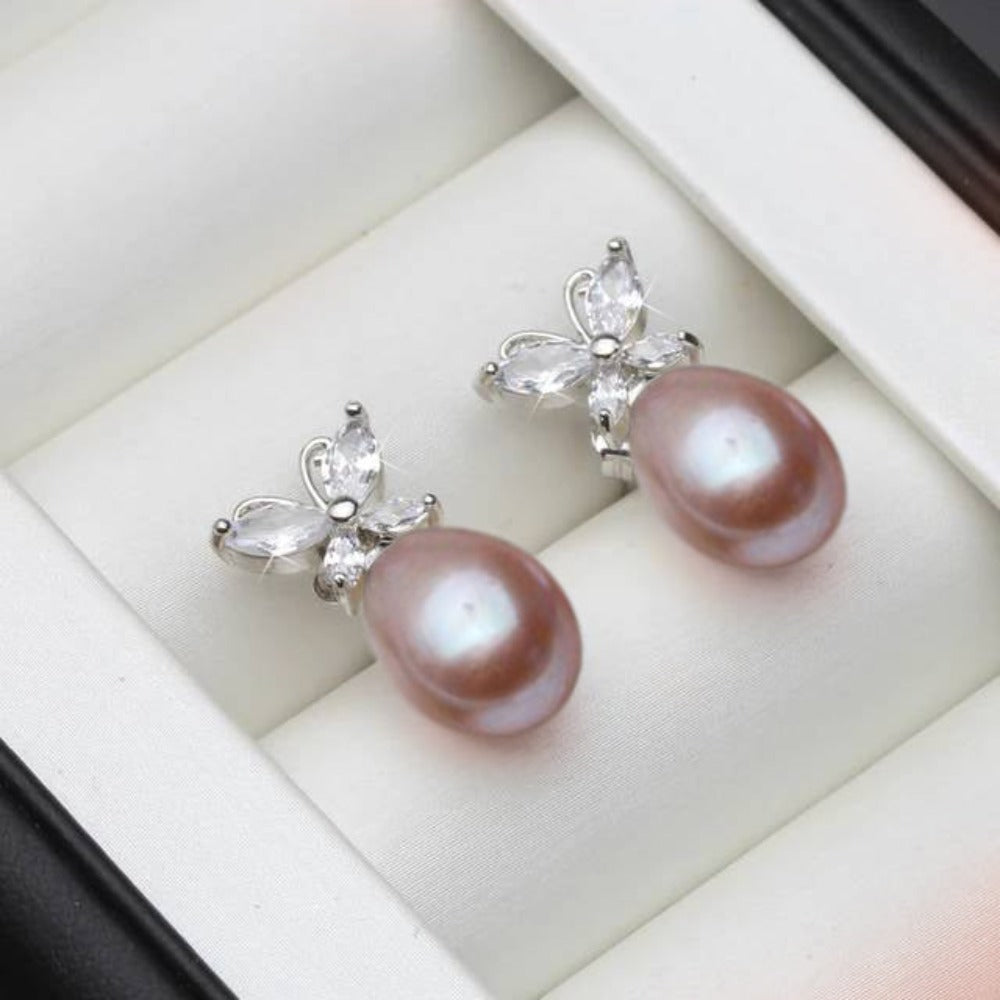 Elegant butterfly stud earrings featuring genuine white freshwater pearls and simulated diamonds, showcasing a delicate design.