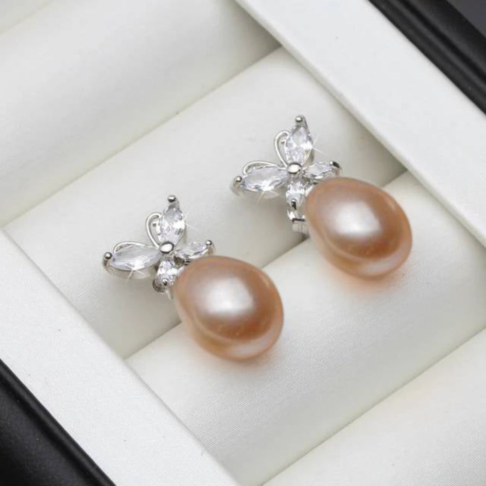 Elegant butterfly stud earrings featuring genuine white freshwater pearls and simulated diamonds, showcasing a delicate design.