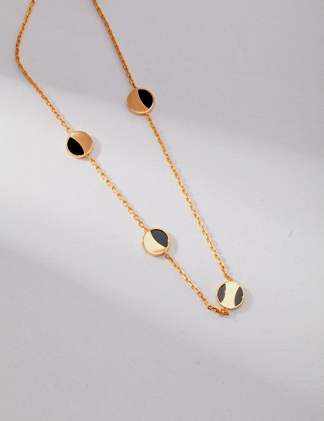 A stunning Geometric Round Black Onyx Necklace featuring a round black onyx pendant on a gold vermeil chain, elegantly displayed.