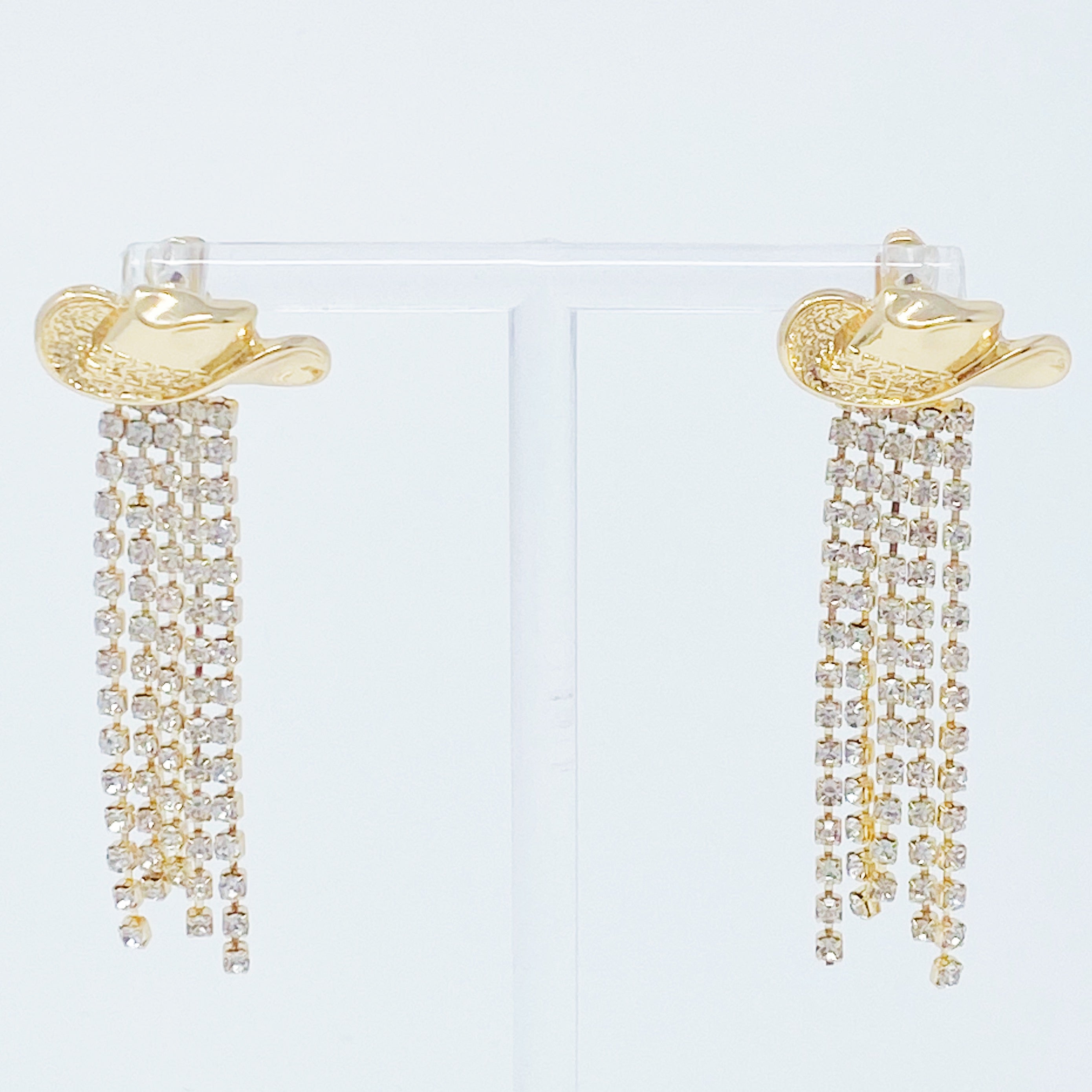 A pair of sparkly gold plated brass cowgirl earrings with a 2-inch drop, showcasing a glamorous design.