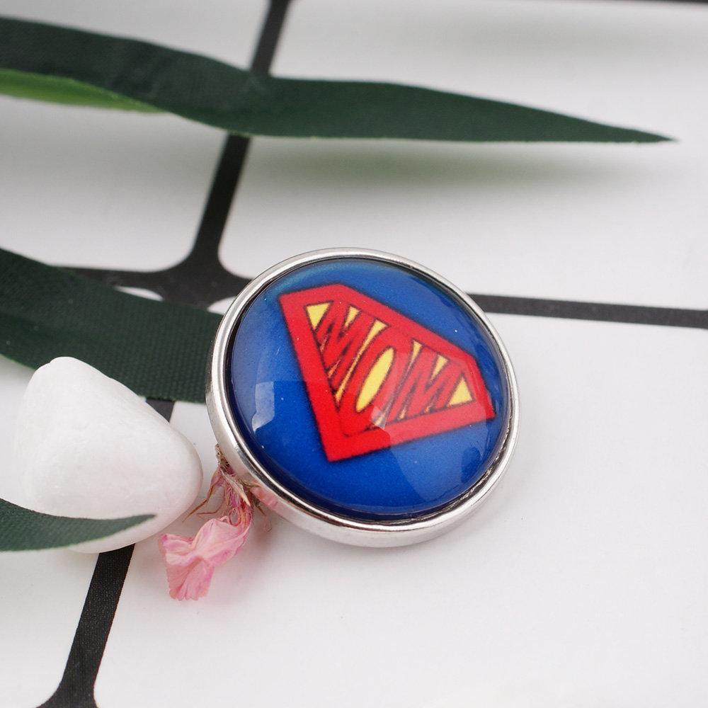 A vibrant 'Super Mom' Glass Dome Snap featuring a magnifying glass dome, designed for interchangeable snap jewelry.
