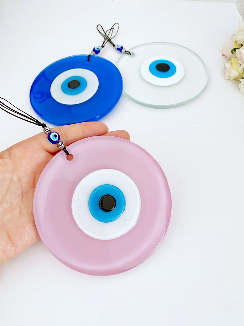 Handmade Glass Evil Eye Bead in pink and blue, perfect for baby room decor and protection, featuring a unique design.