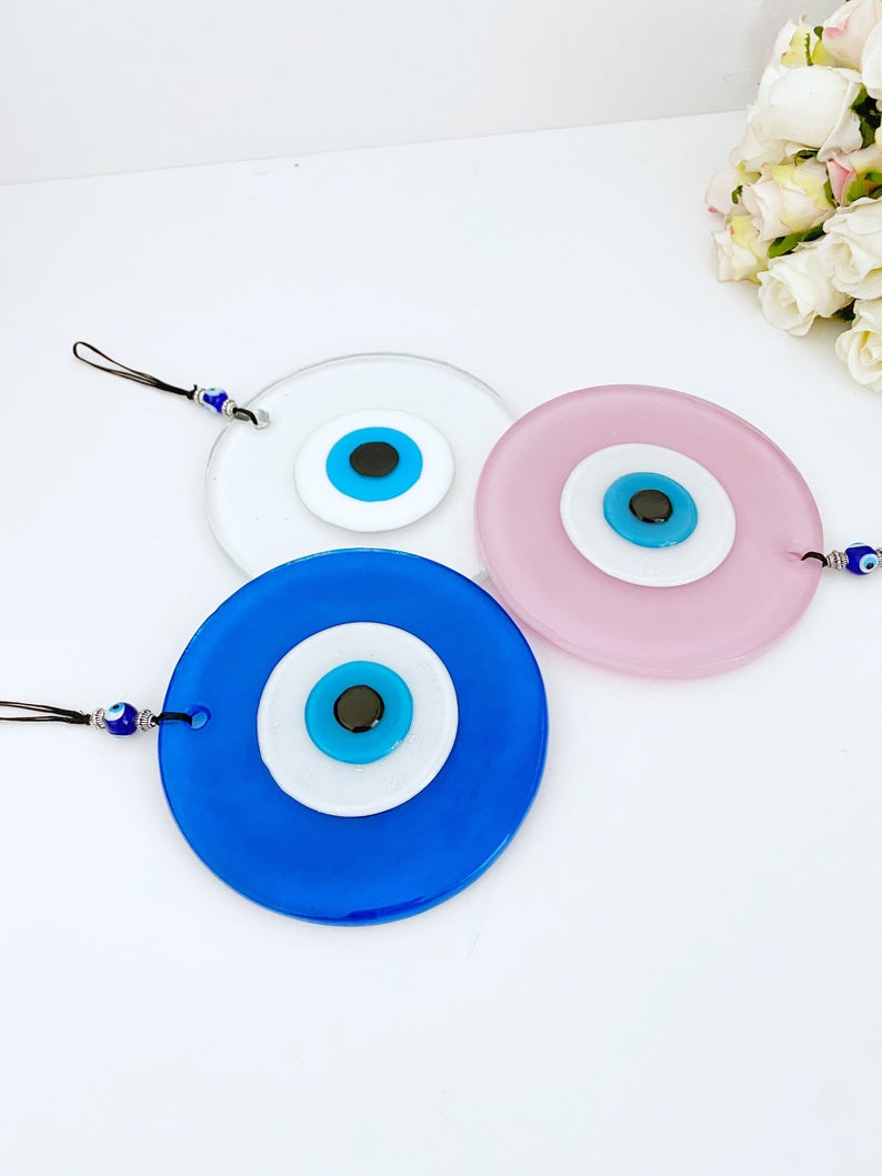 Handmade Glass Evil Eye Bead in pink and blue, perfect for baby room decor and protection, featuring a unique design.