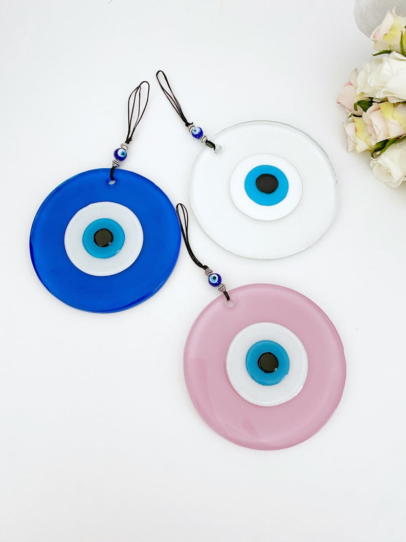 Handmade Glass Evil Eye Bead in pink and blue, perfect for baby room decor and protection, featuring a unique design.