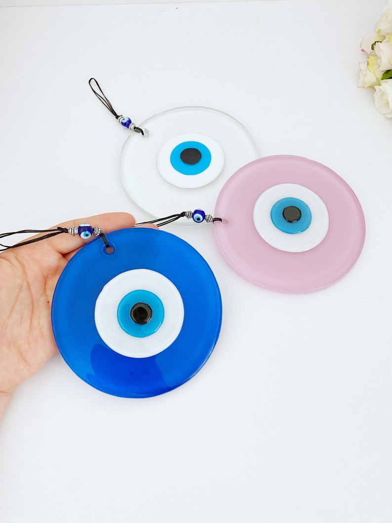 Handmade Glass Evil Eye Bead in pink and blue, perfect for baby room decor and protection, featuring a unique design.