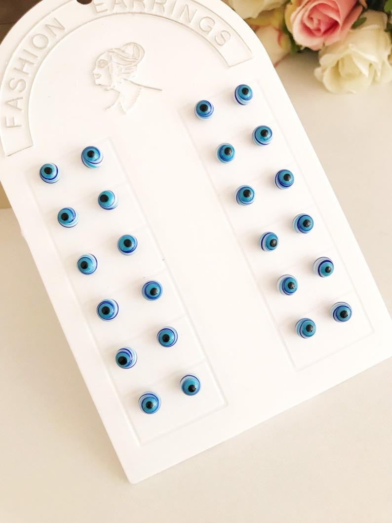 A pair of handmade Glass Evil Eye Stud Earrings featuring an 8mm blue evil eye bead with silver finishing, symbolizing protection.