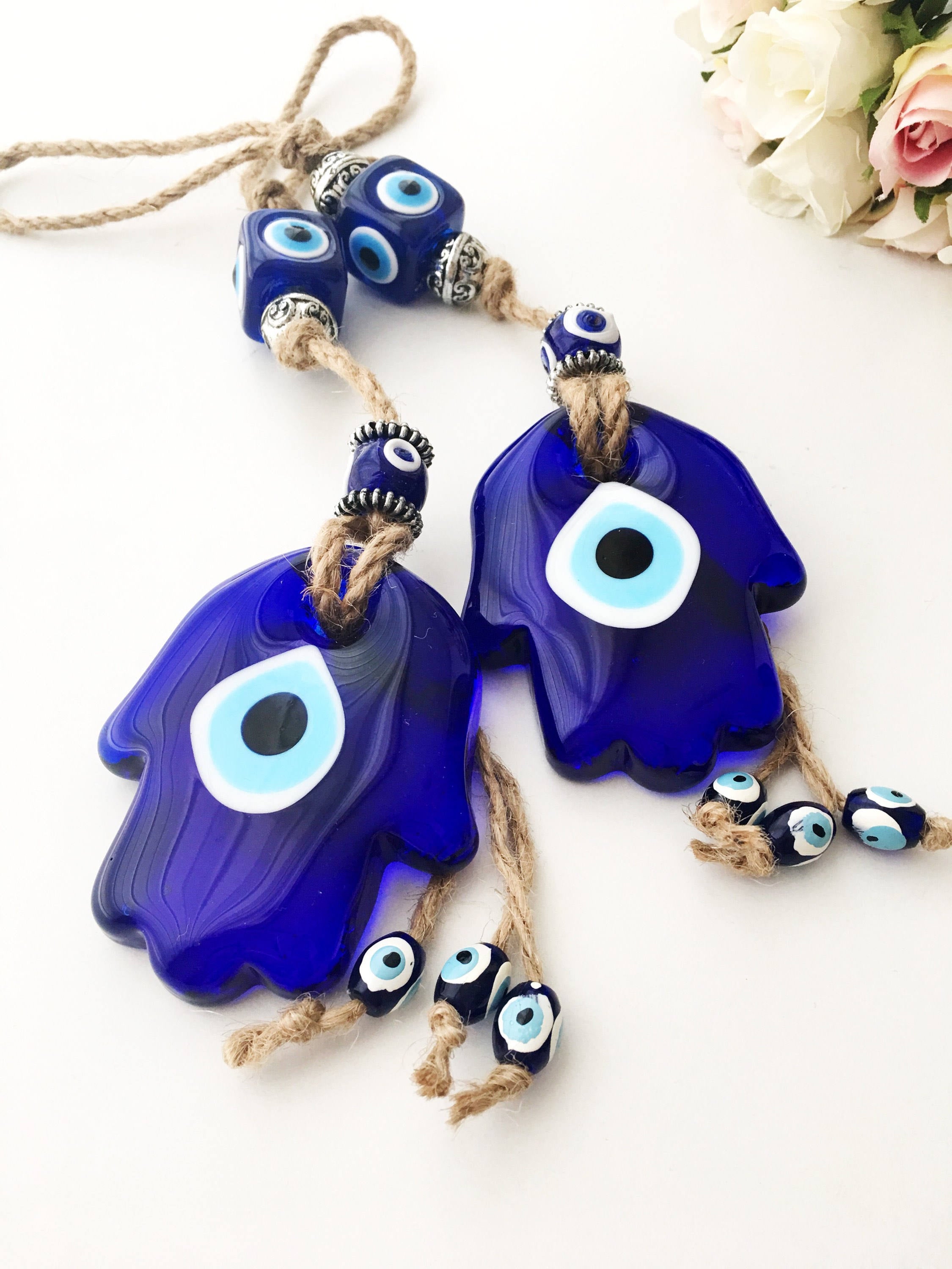 A beautifully crafted Glass Hamsa Evil Eye Wall Hanging featuring intricate macrame and a protective evil eye symbol, handmade in Turkey.