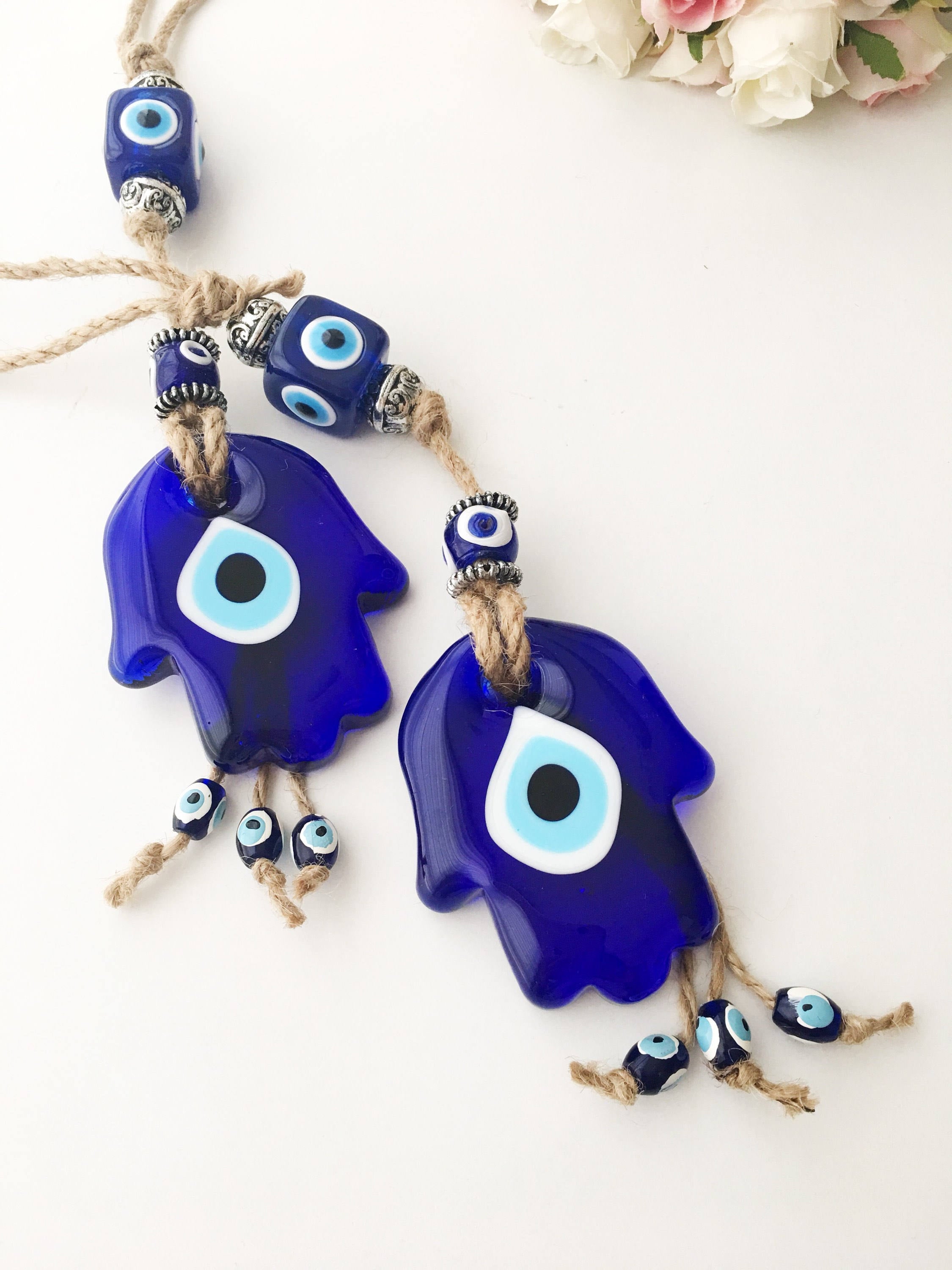 A beautifully crafted Glass Hamsa Evil Eye Wall Hanging featuring intricate macrame and a protective evil eye symbol, handmade in Turkey.