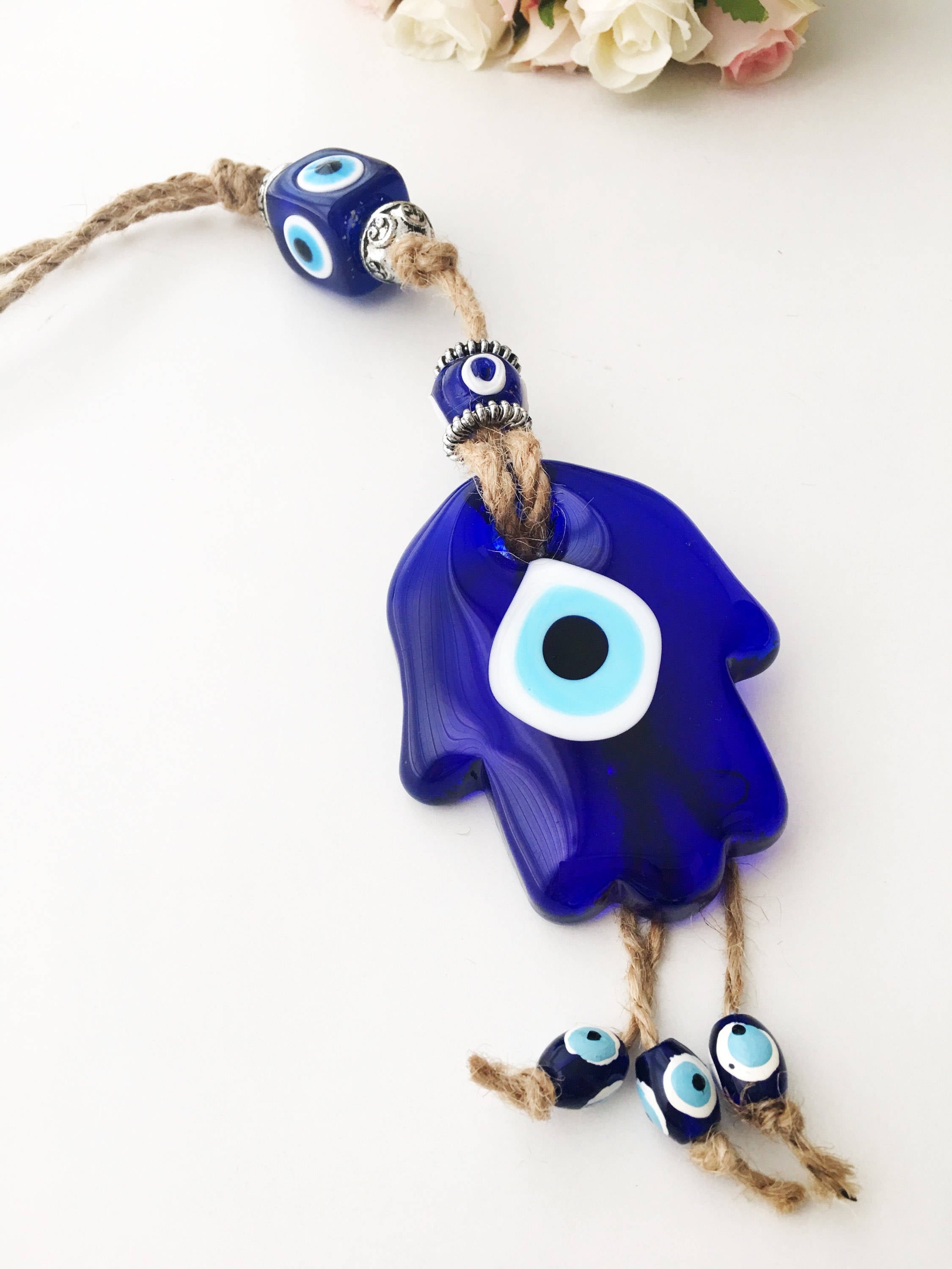 A beautifully crafted Glass Hamsa Evil Eye Wall Hanging featuring intricate macrame and a protective evil eye symbol, handmade in Turkey.