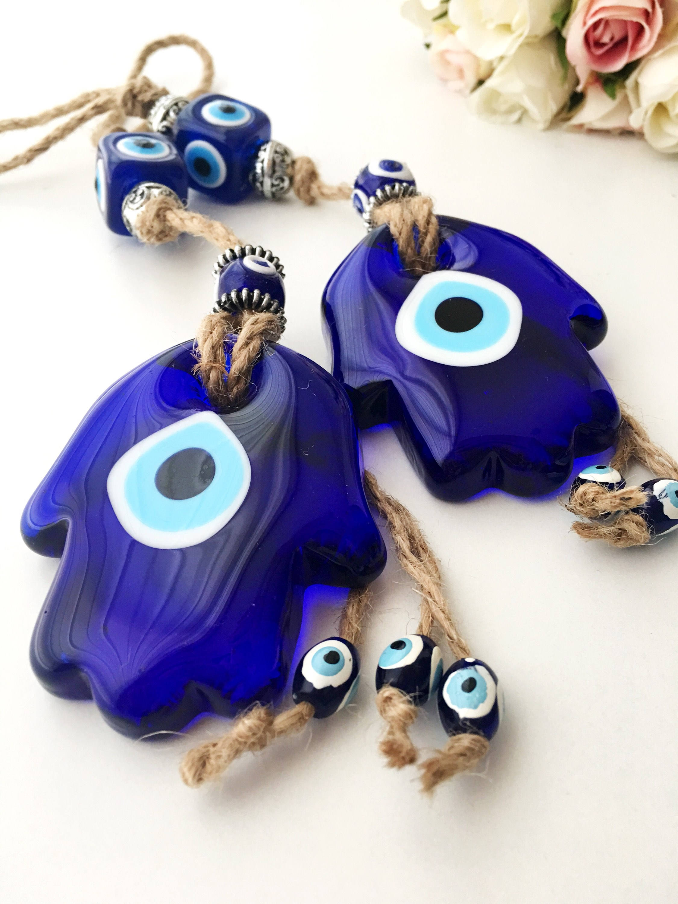 A beautifully crafted Glass Hamsa Evil Eye Wall Hanging featuring intricate macrame and a protective evil eye symbol, handmade in Turkey.