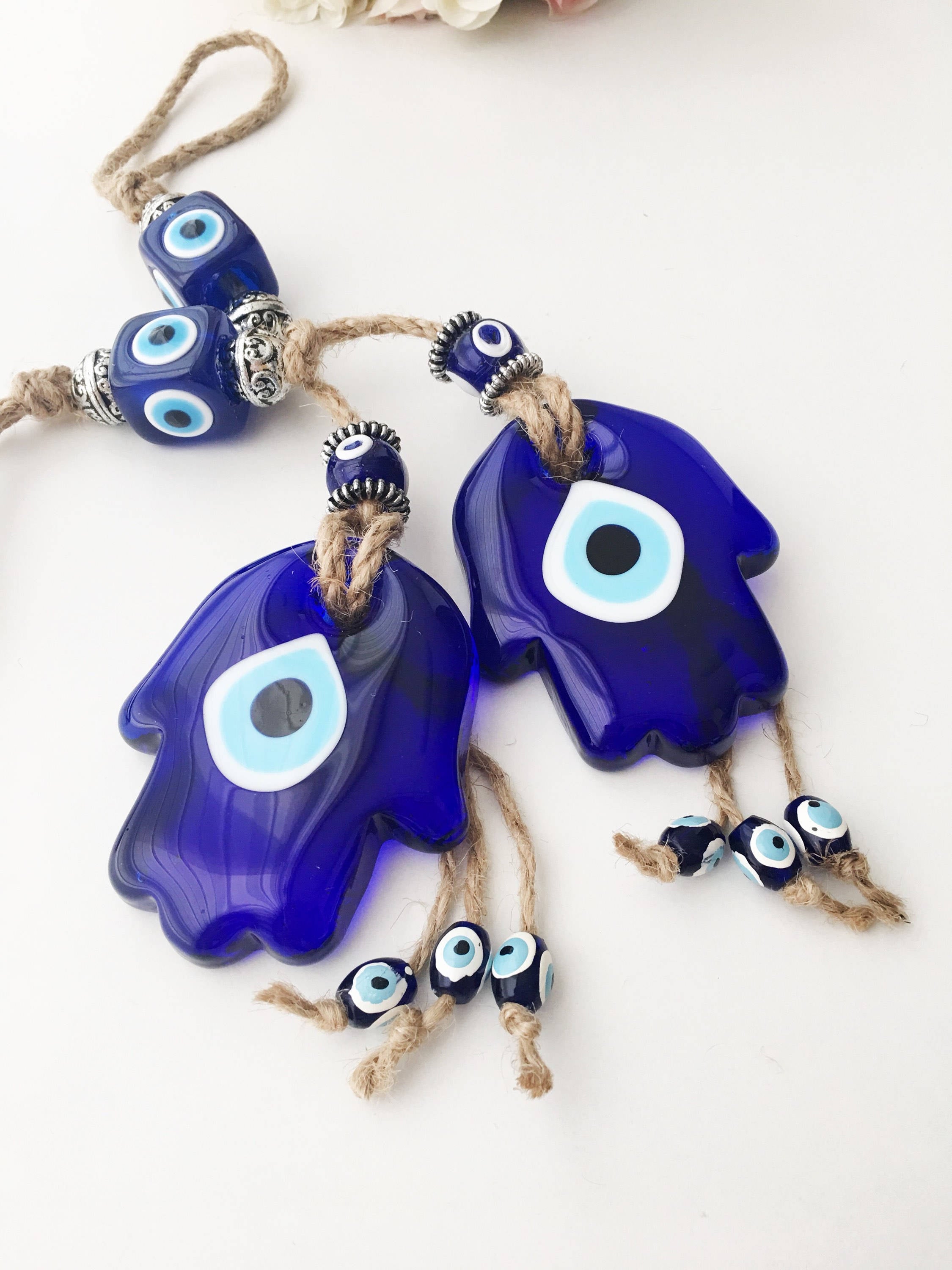 A beautifully crafted Glass Hamsa Evil Eye Wall Hanging featuring intricate macrame and a protective evil eye symbol, handmade in Turkey.