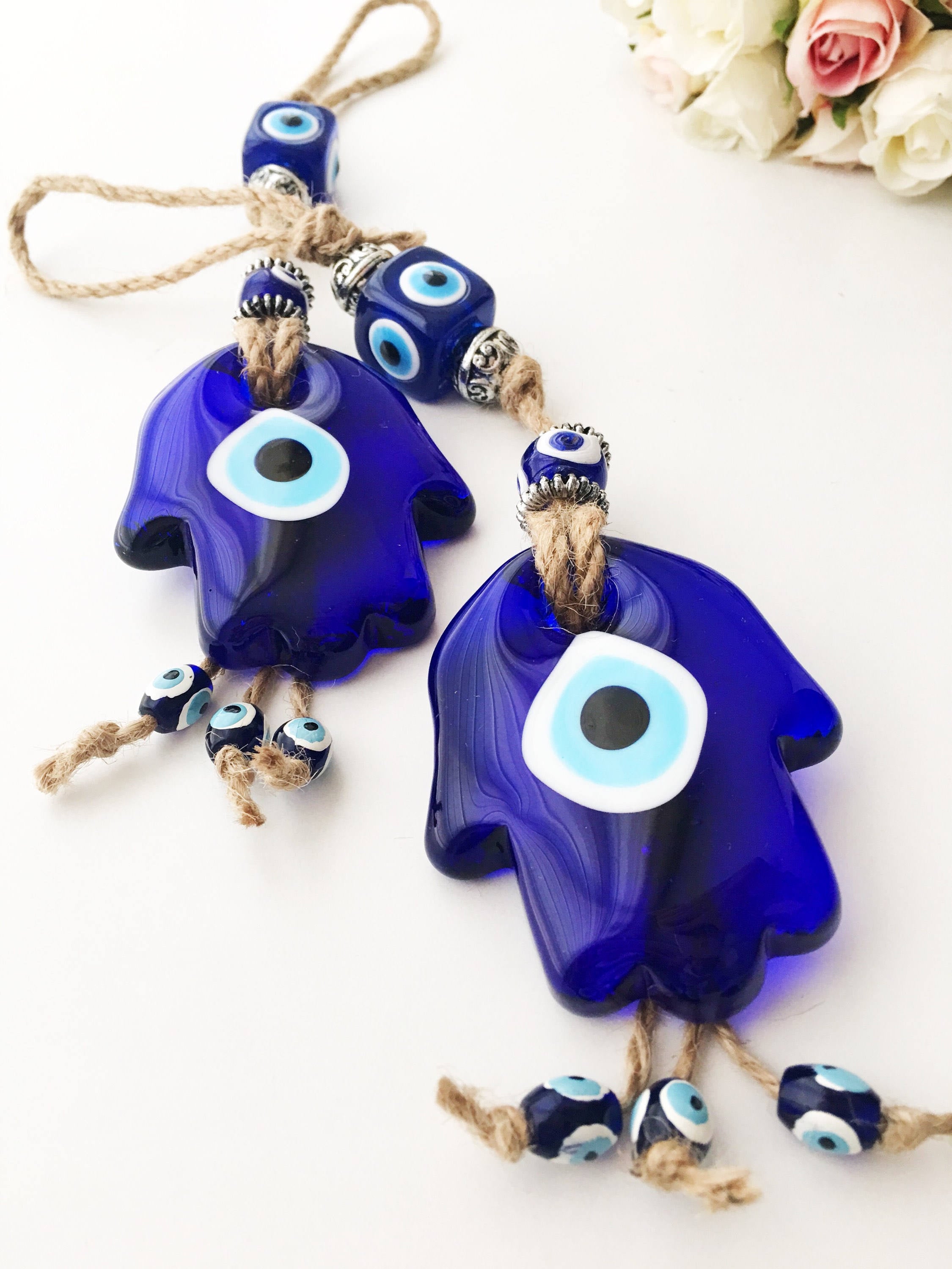 A beautifully crafted Glass Hamsa Evil Eye Wall Hanging featuring intricate macrame and a protective evil eye symbol, handmade in Turkey.