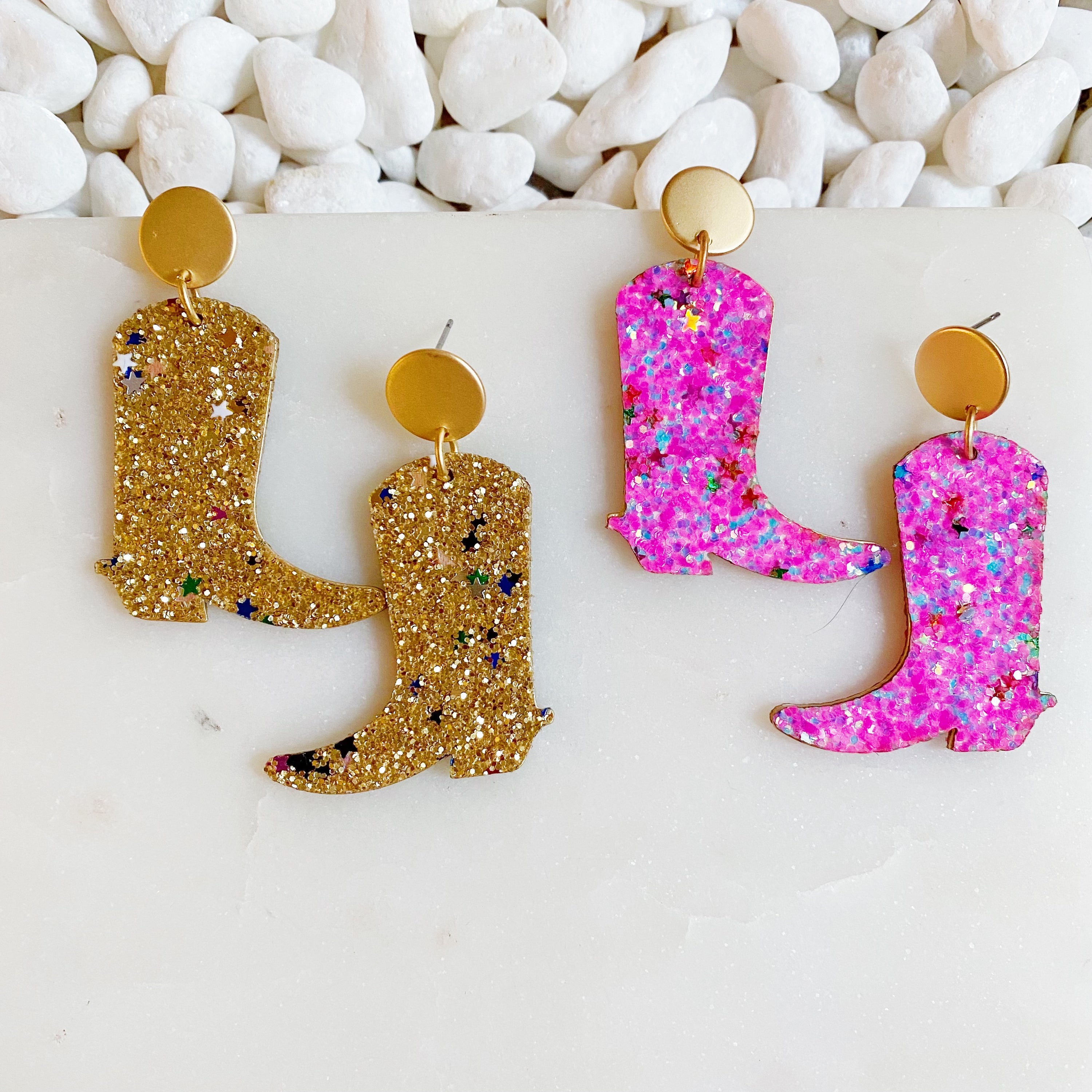A pair of glittered cowgirl boot earrings with stars, showcasing a fun and trendy design.